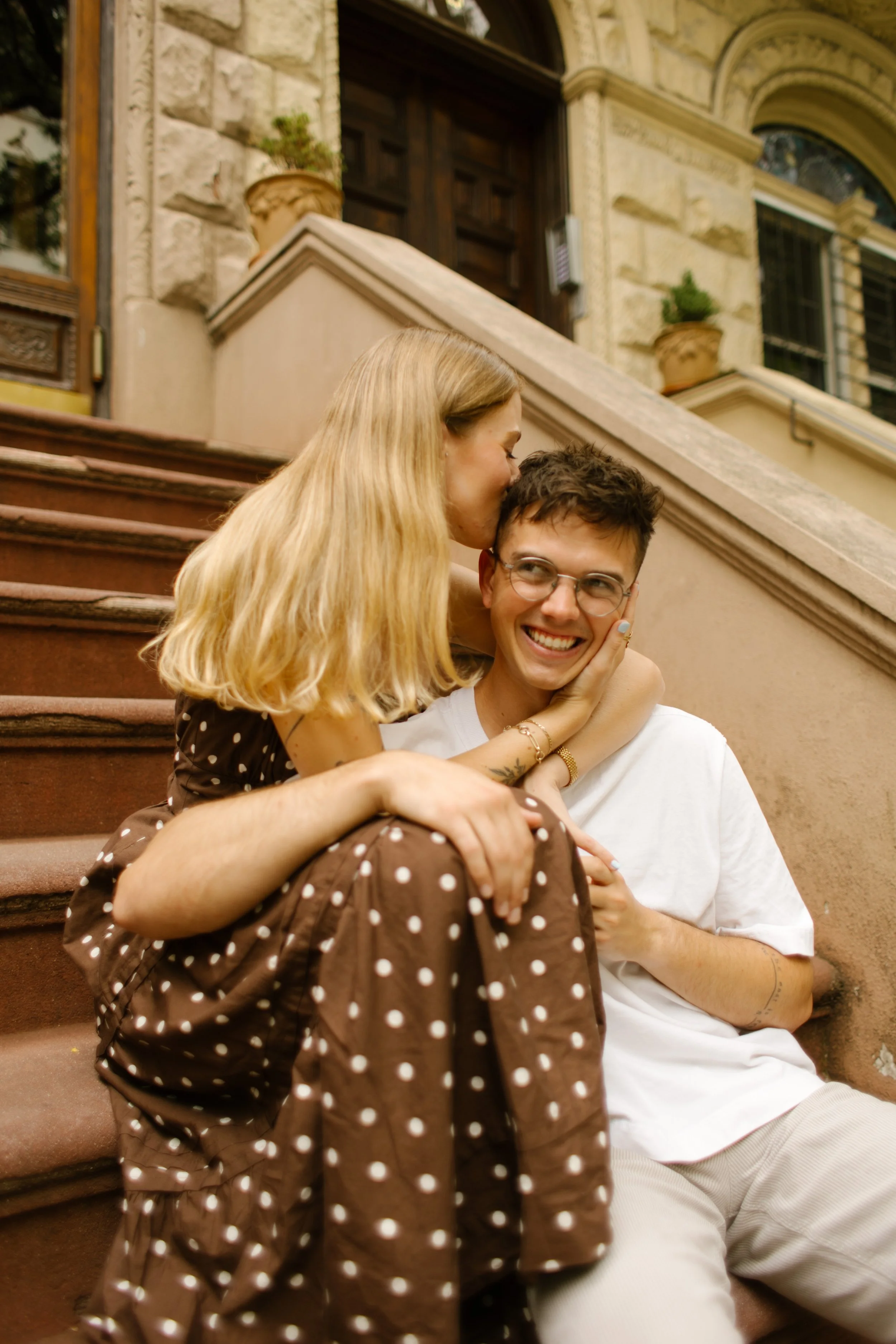 New York engagement photographer capturing a candid brownstone stoop portrait in Brooklyn.