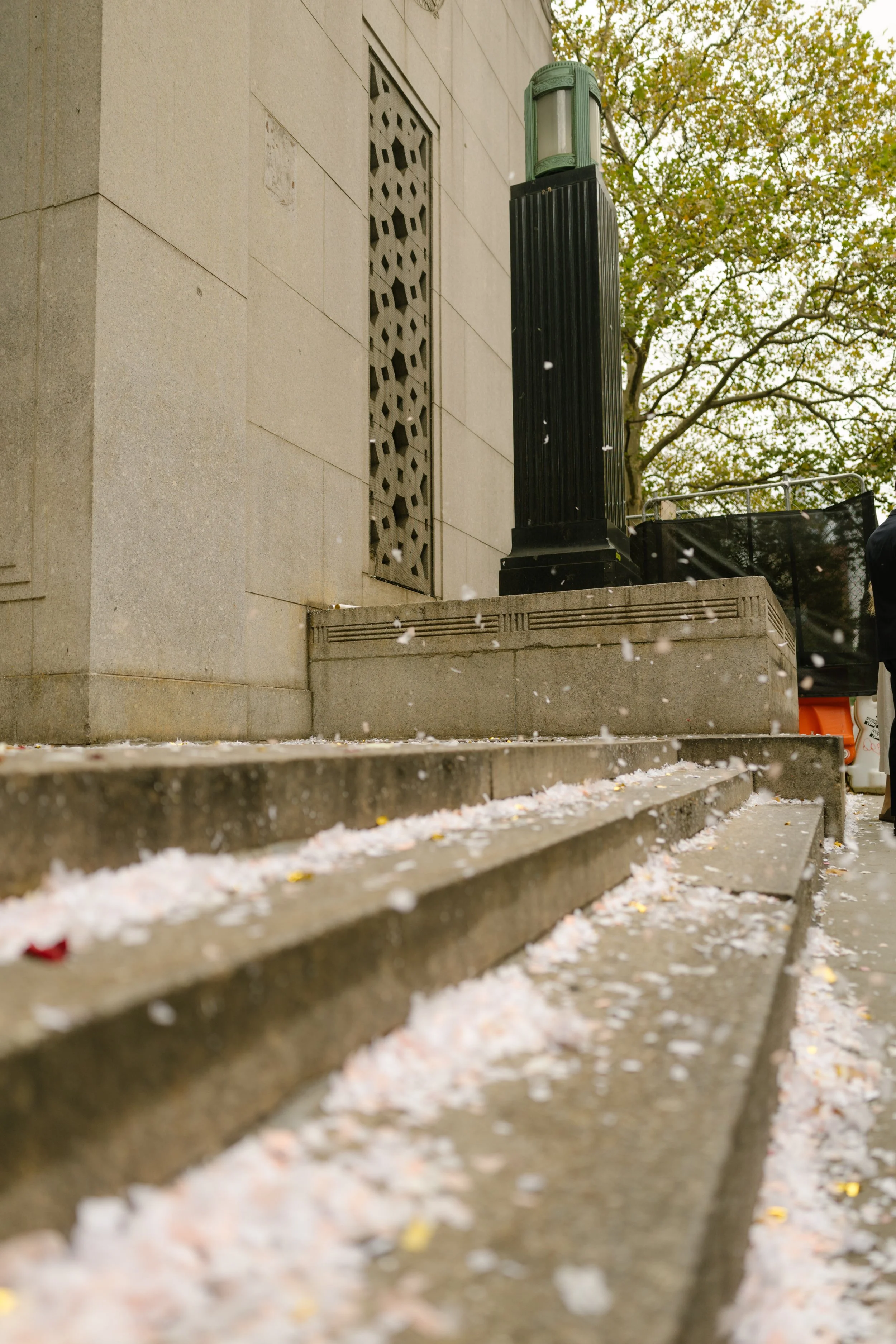 Confetti scattered across ceremony steps outside Manhattan wedding venue after celebration