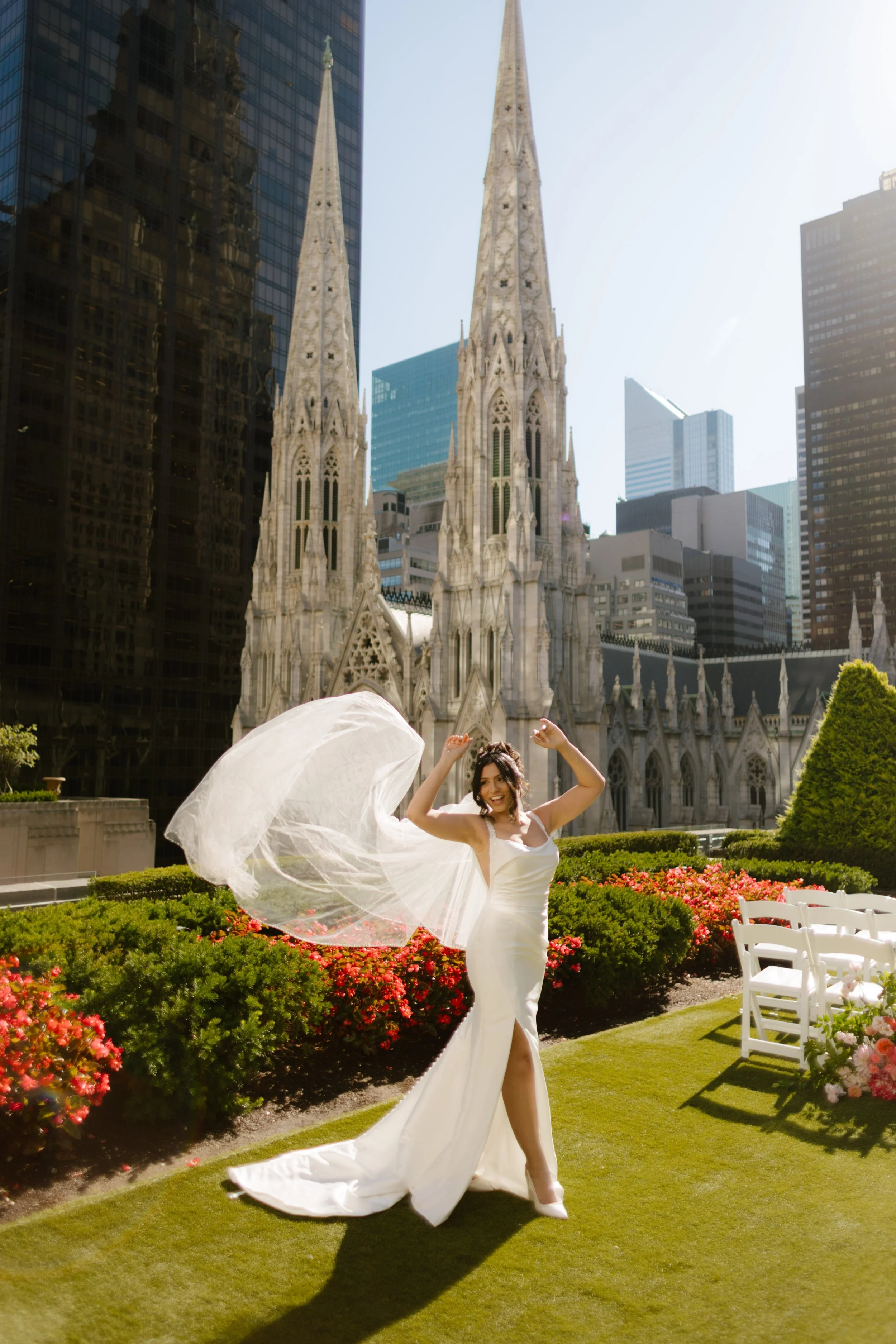Bride twirling veil on rooftop terrace overlooking St. Patrick’s Cathedral in New York City