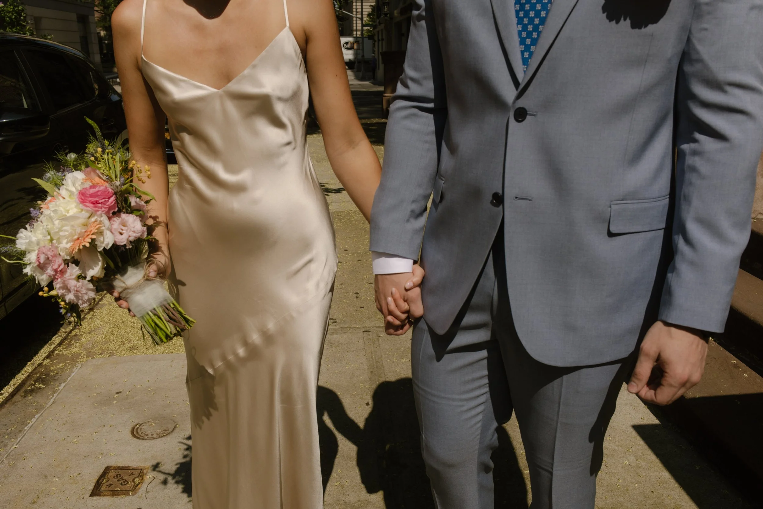 Bride and groom holding hands while walking through Manhattan streets after New York Wedding ceremony