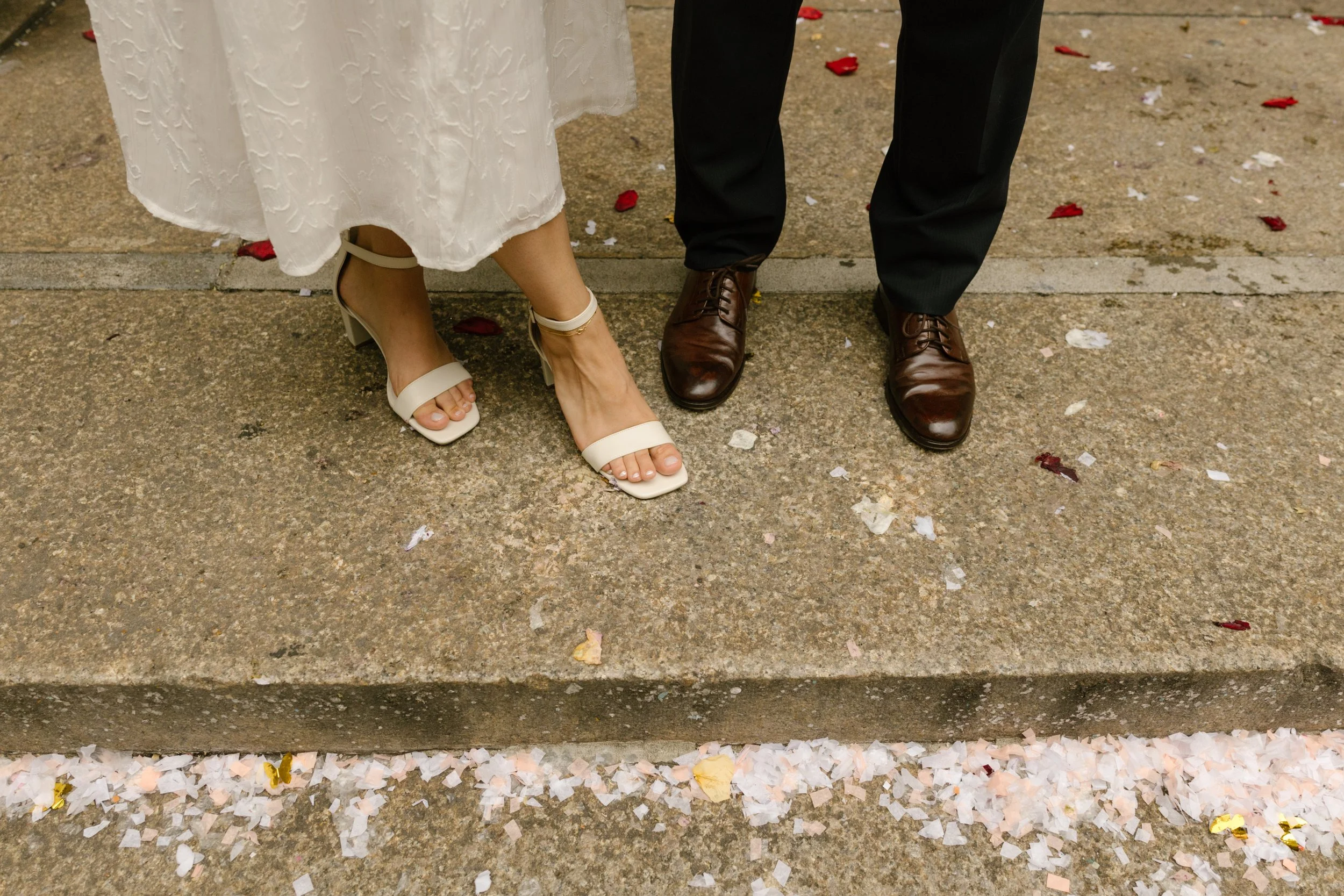Newlyweds standing beside scattered flower petals after New York Wedding ceremony exit