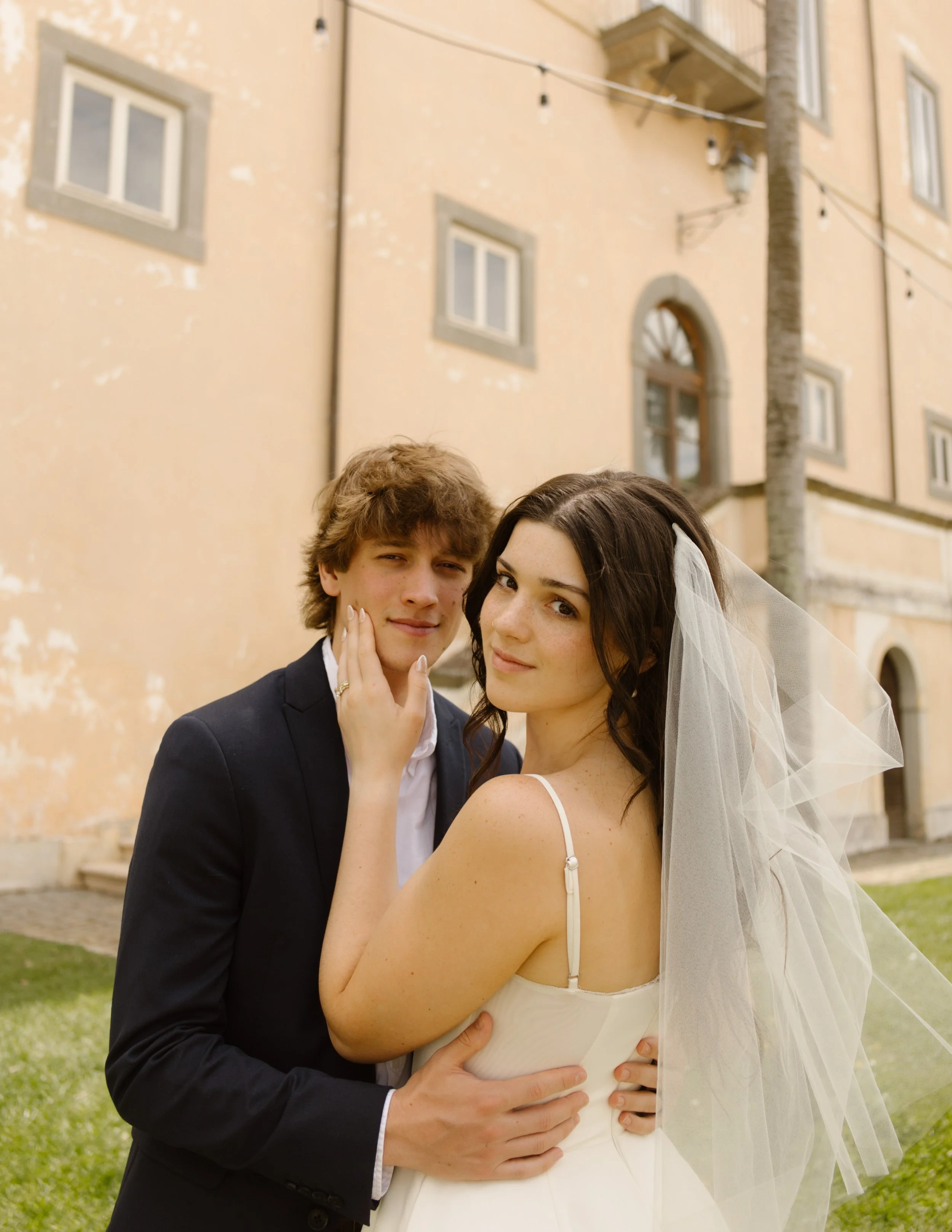 Bride and groom embracing outside a historic villa during a destination wedding in Italy