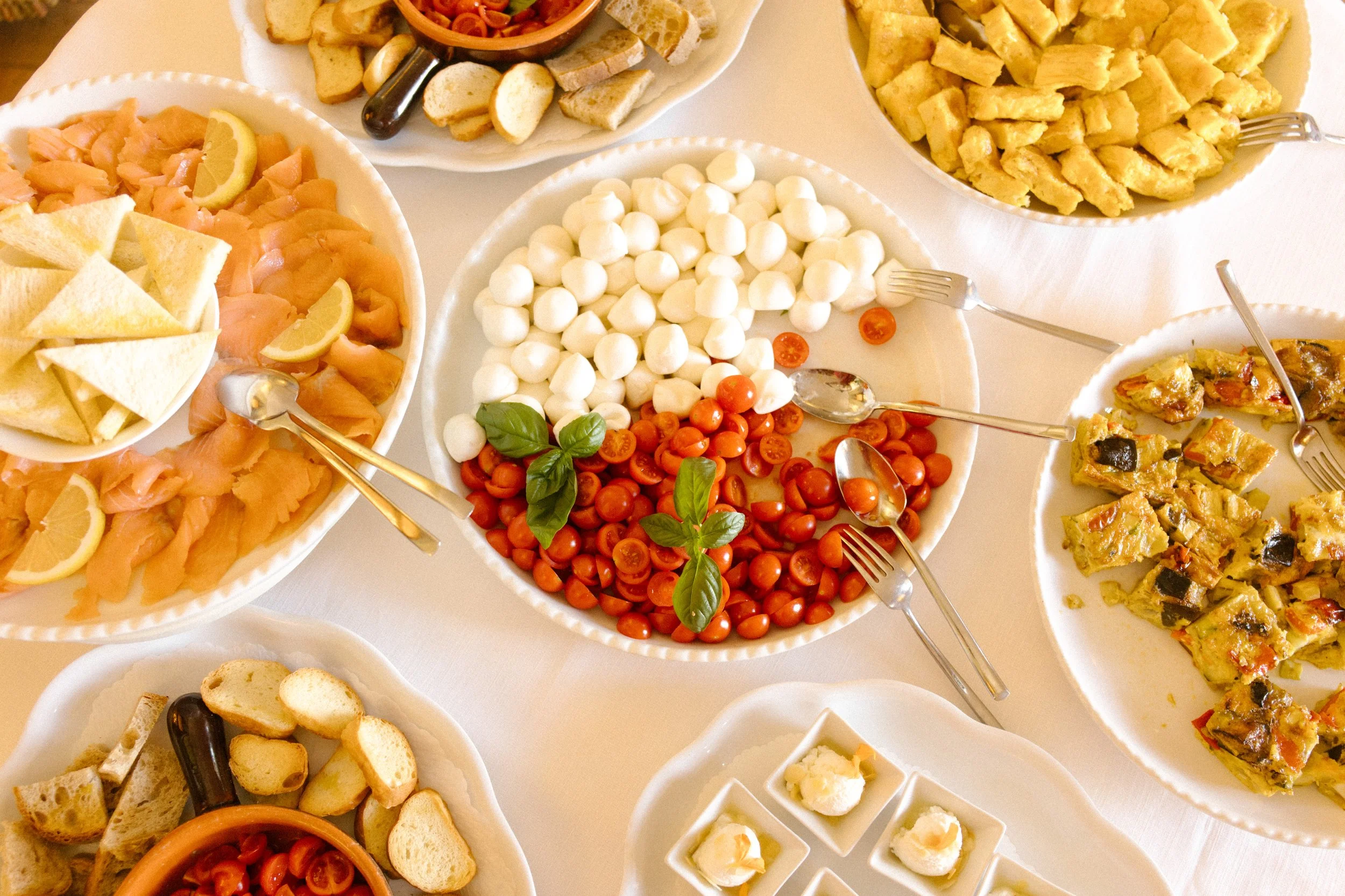 Italian brunch spread with mozzarella, tomatoes, pastries, and fresh fruit during a destination wedding in Italy