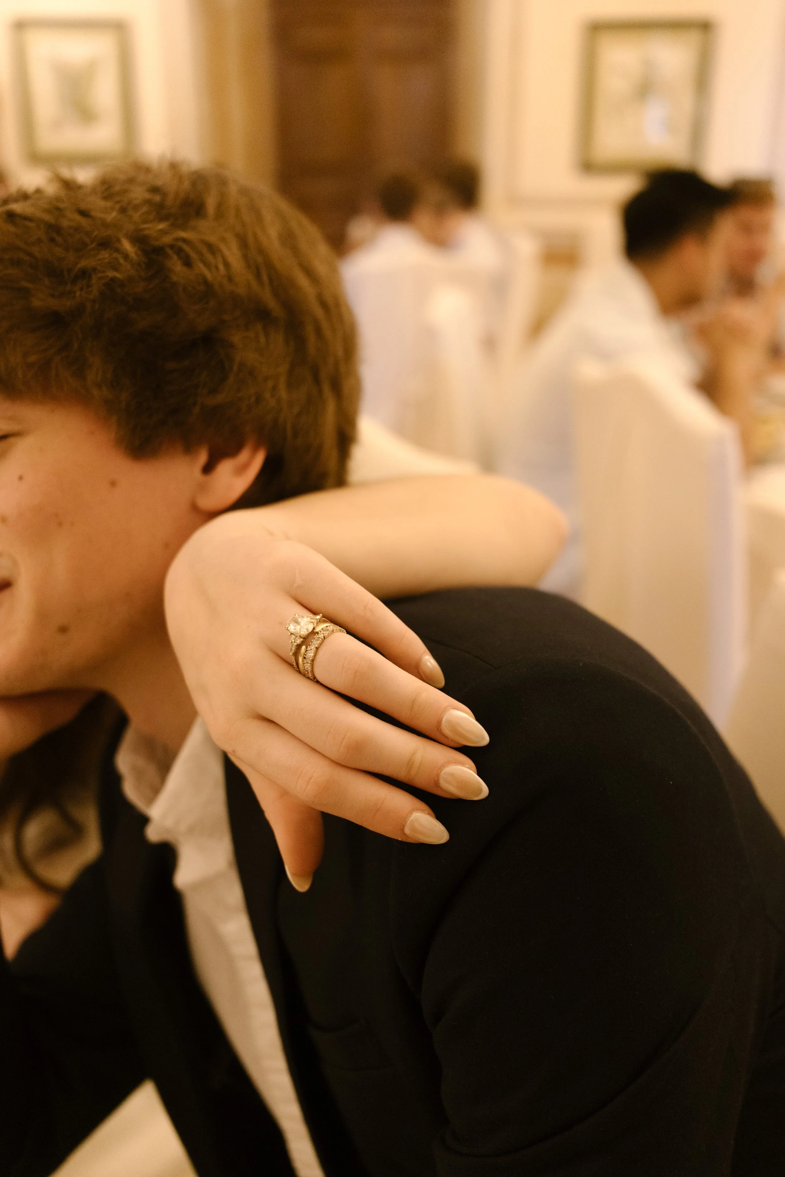Close-up of wedding rings and bride resting her arm on groom during an Italy wedding reception