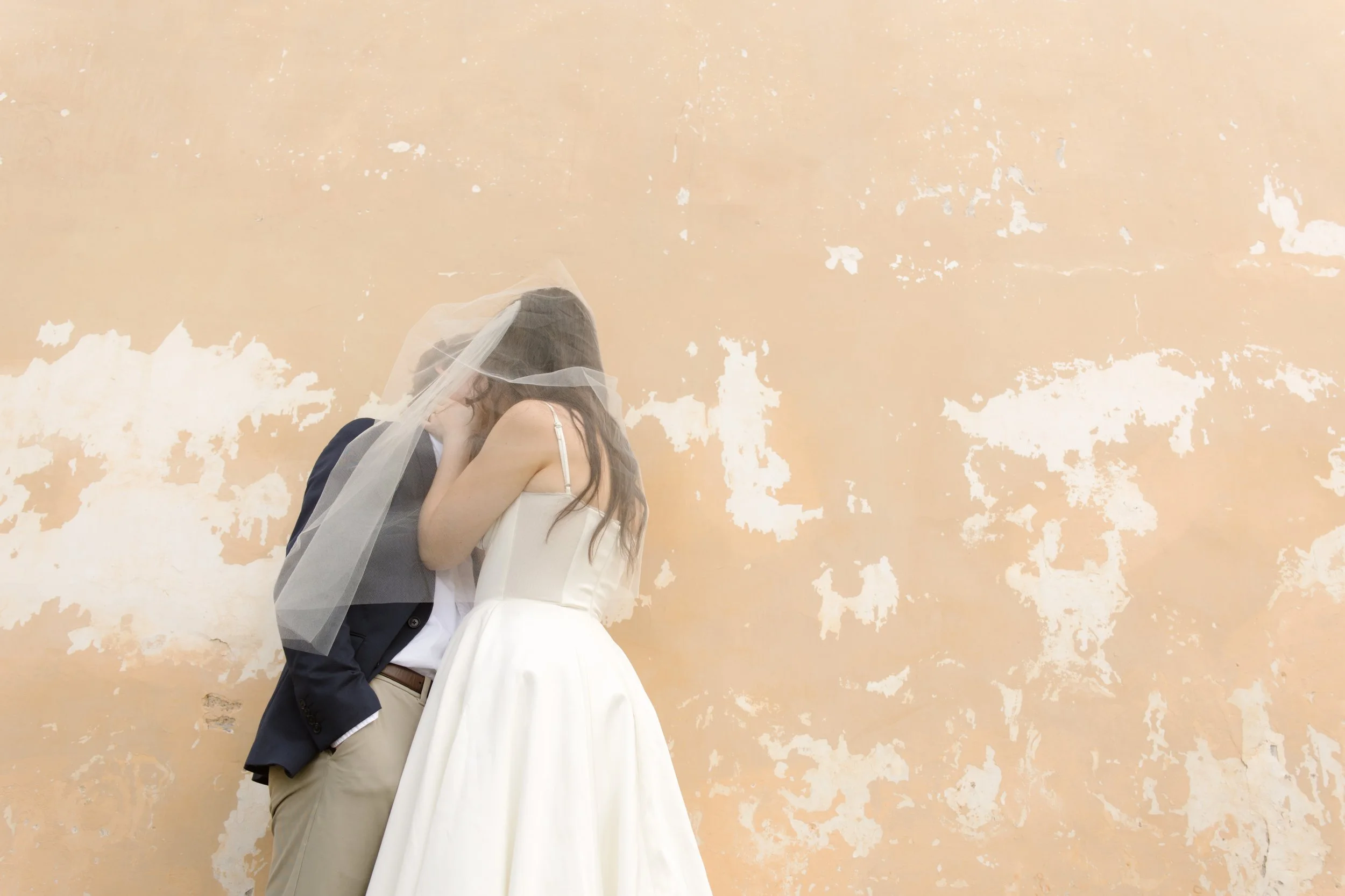 Romantic bride and groom portrait against a textured Italian villa wall during an Italy wedding weekend