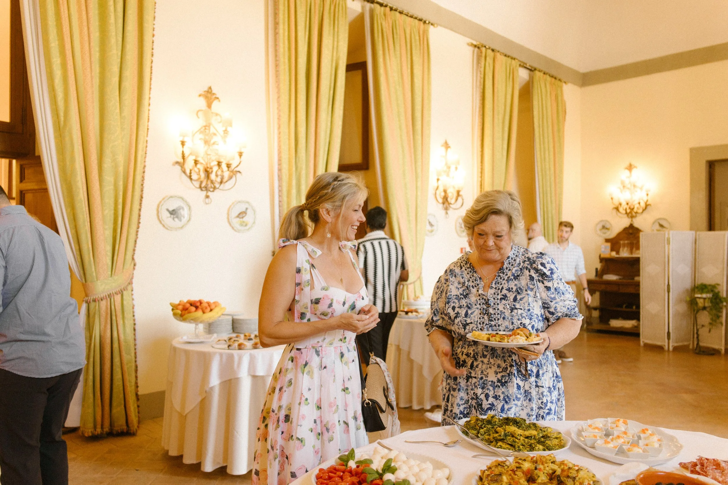 Guests gathering around a buffet during a destination wedding in Italy farewell brunch inside a historic villa reception space