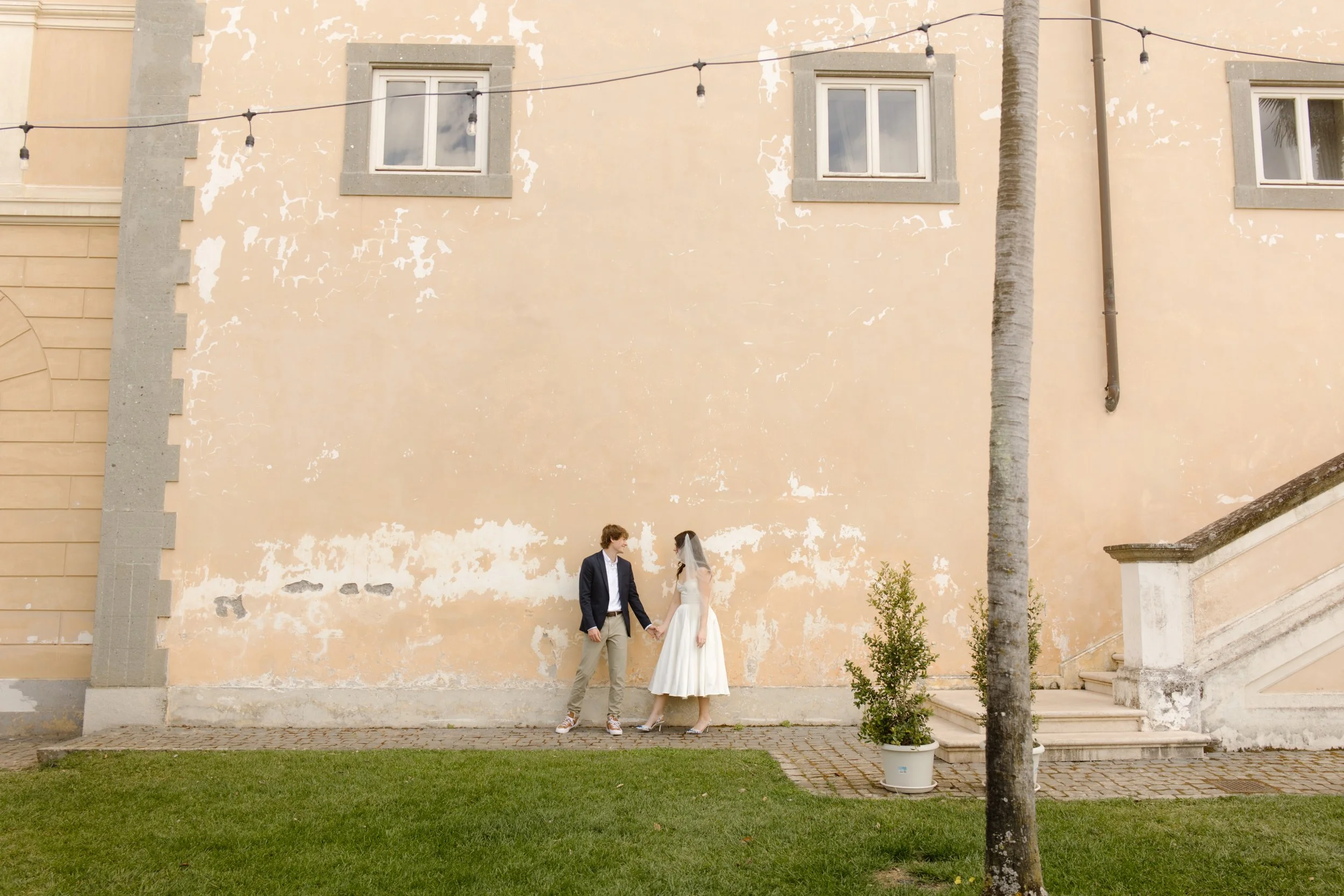 Couple holding hands outside a romantic Italian villa during a destination wedding in Italy wedding weekend
