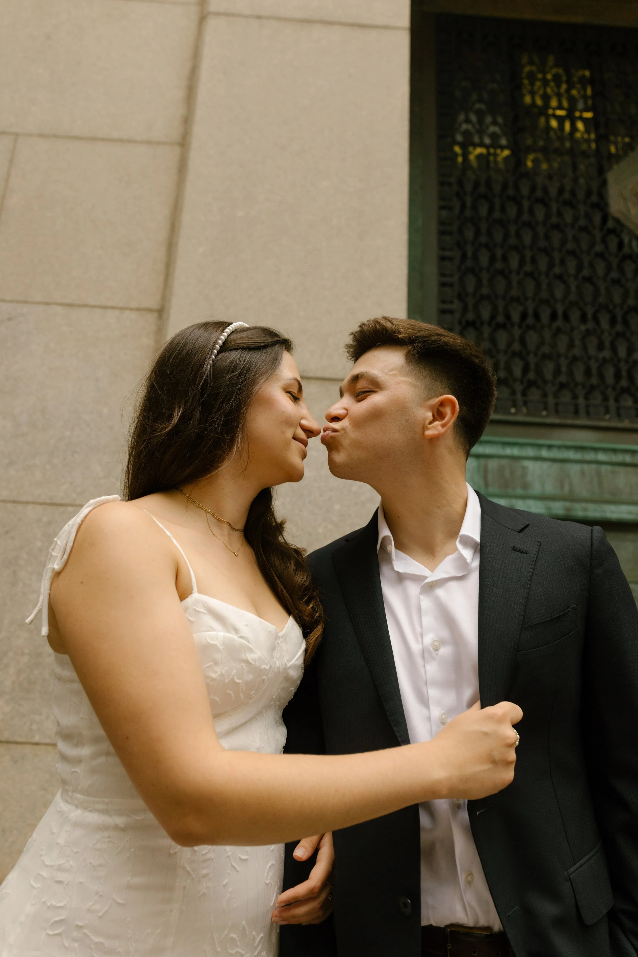 Bride and groom leaning in for a kiss outside courthouse after their New York courthouse wedding