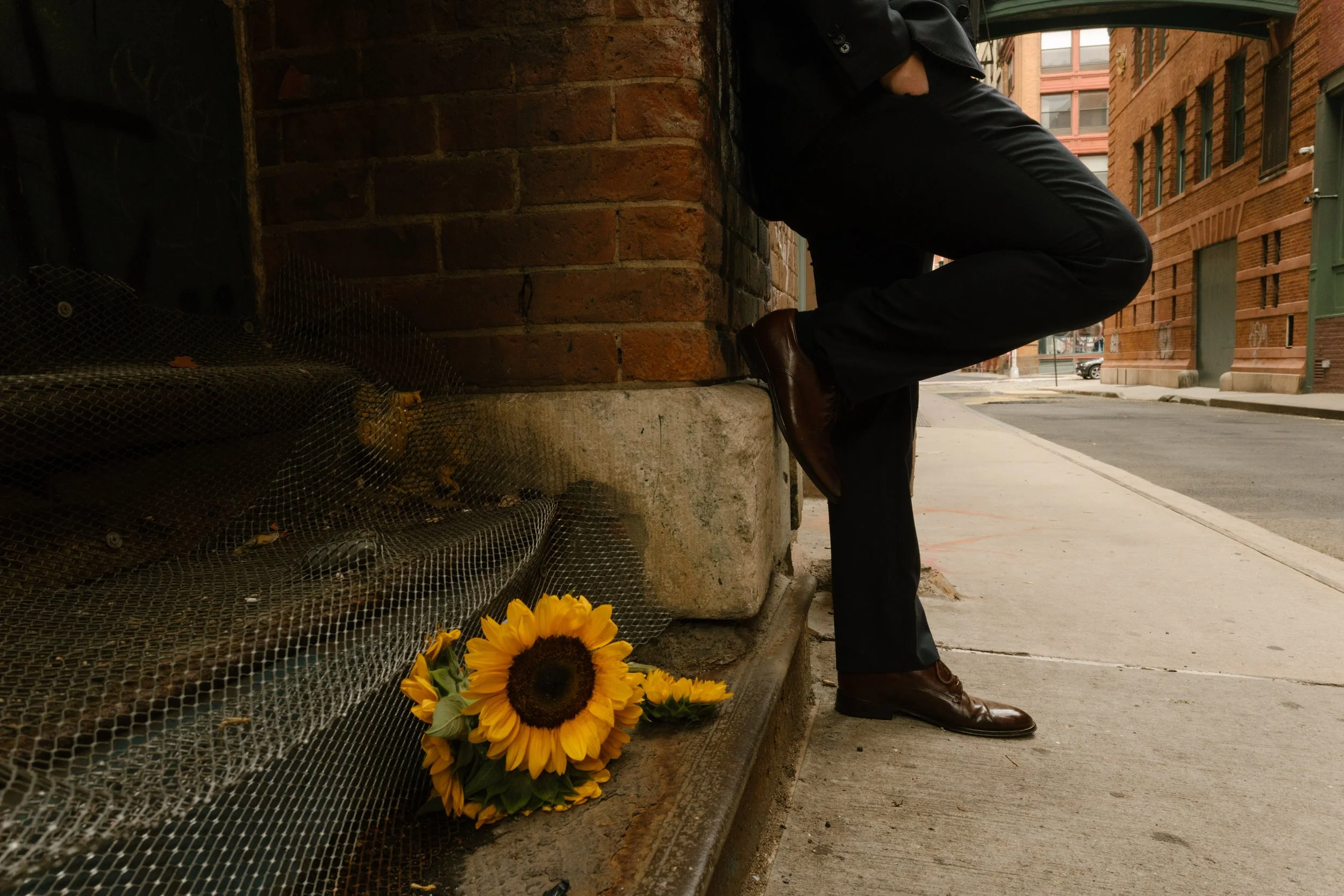 Sunflower bouquet resting on city sidewalk during intimate NYC elopement photos