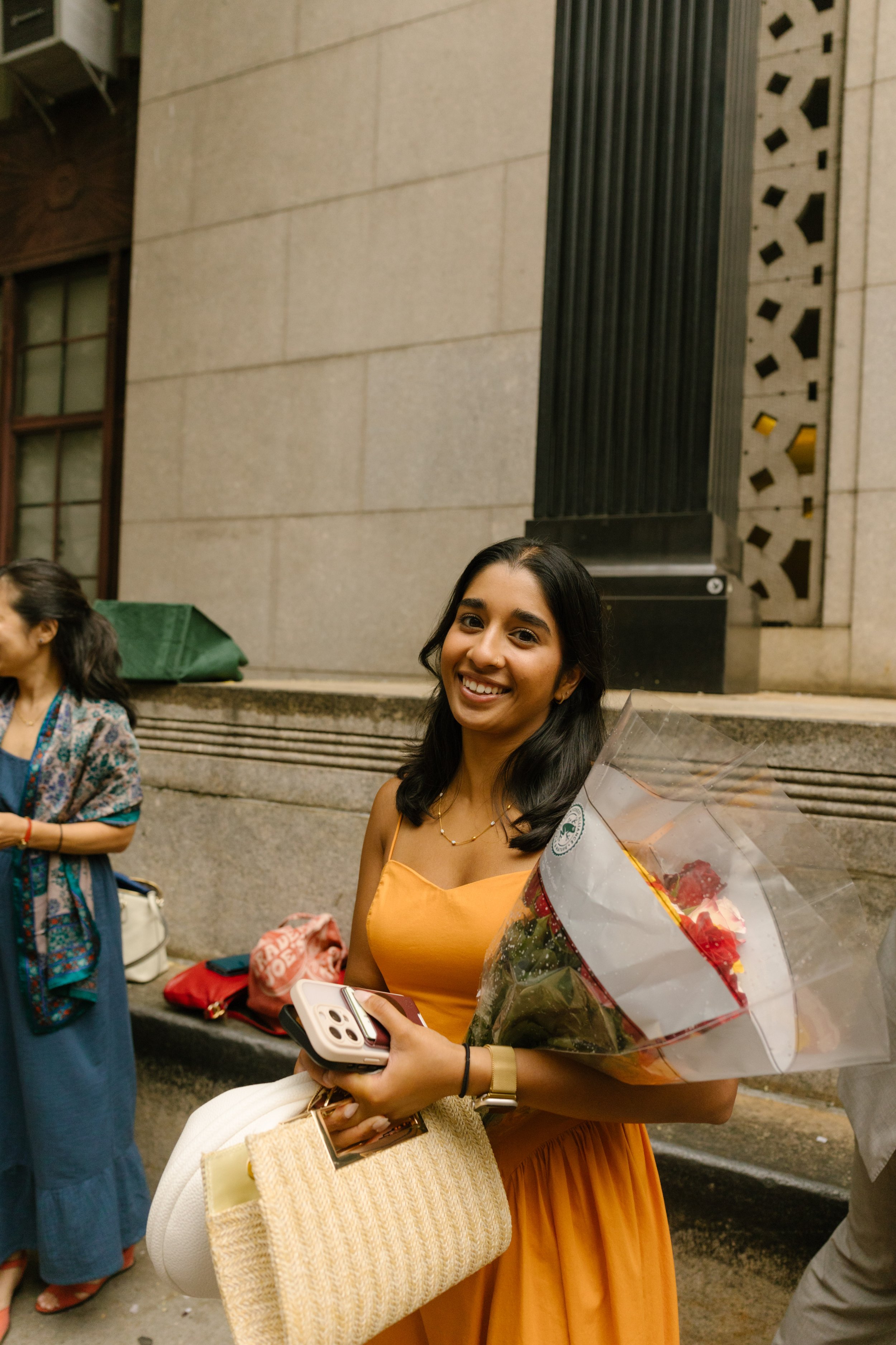 Wedding guest holding flowers outside the NYC City Clerk’s Office during courthouse wedding celebration