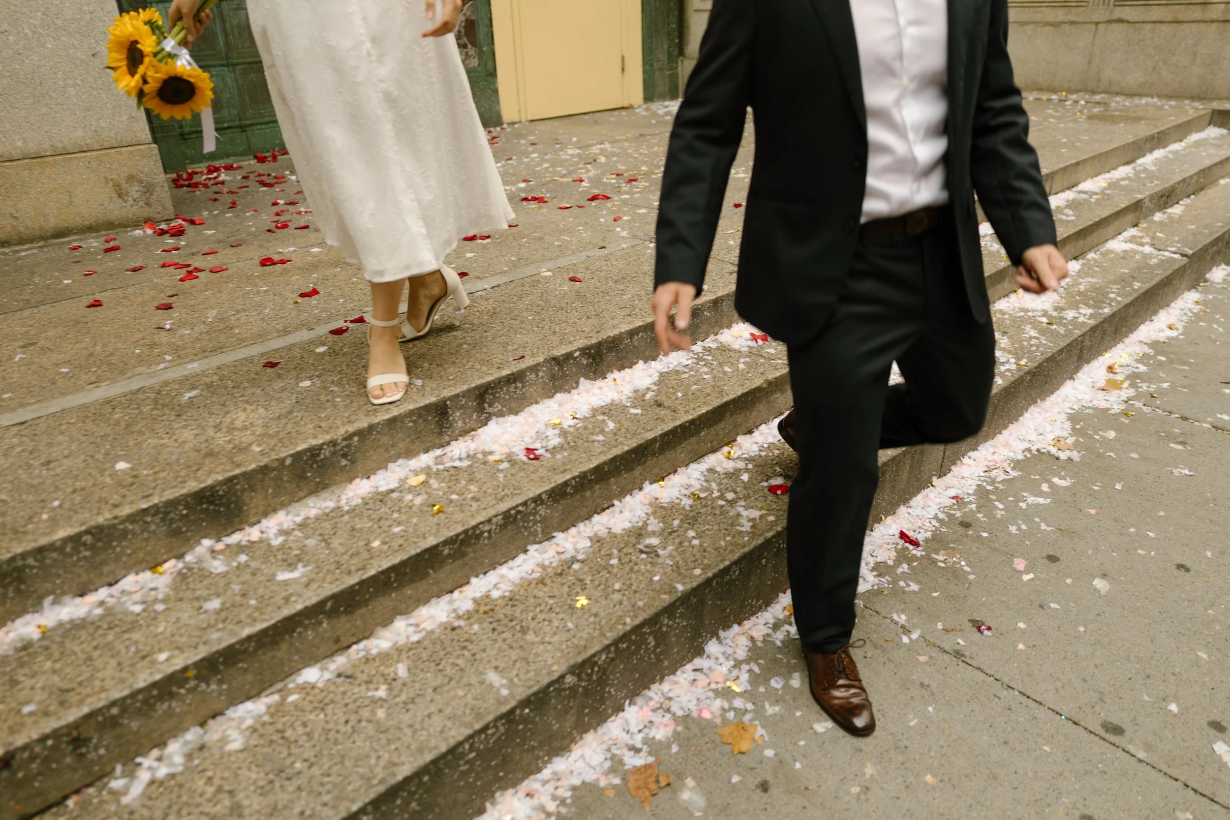 Couple walking through confetti outside the NYC courthouse after an intimate New York wedding ceremony