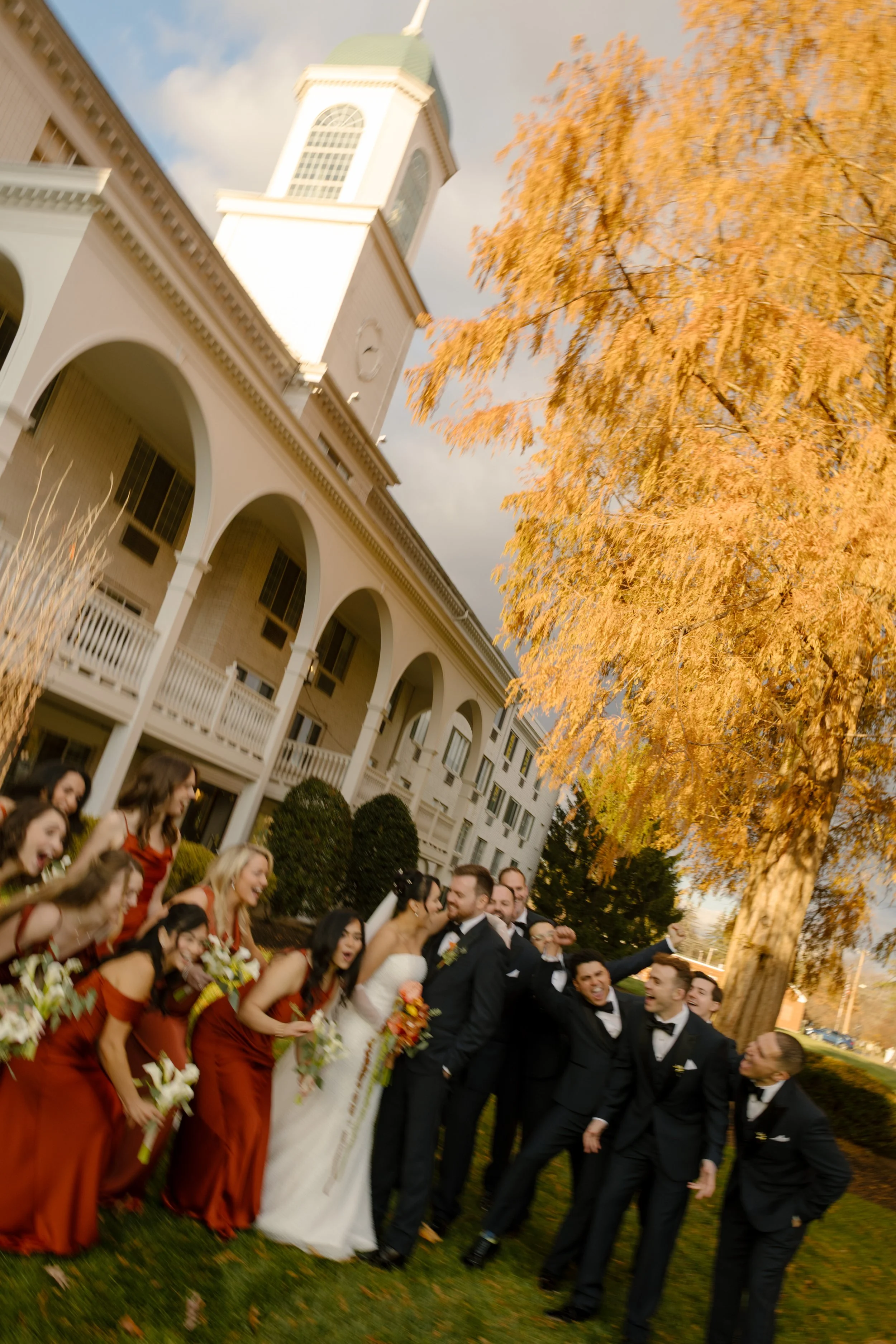 Wedding party gathered outside a classic estate venue during a joyful wedding in New York portrait session