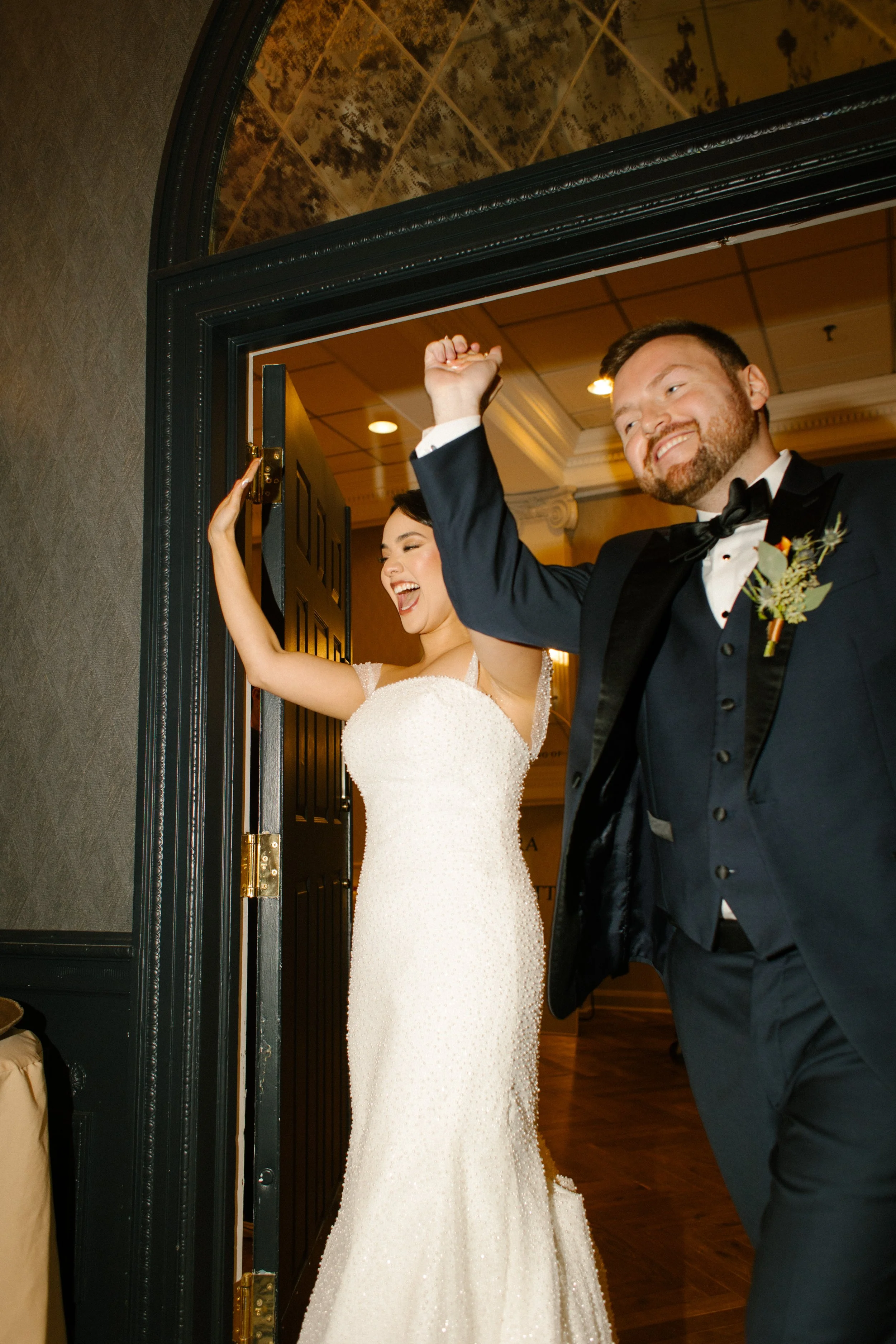 Bride and groom making a celebratory reception entrance with guests cheering during their wedding in New York festivities