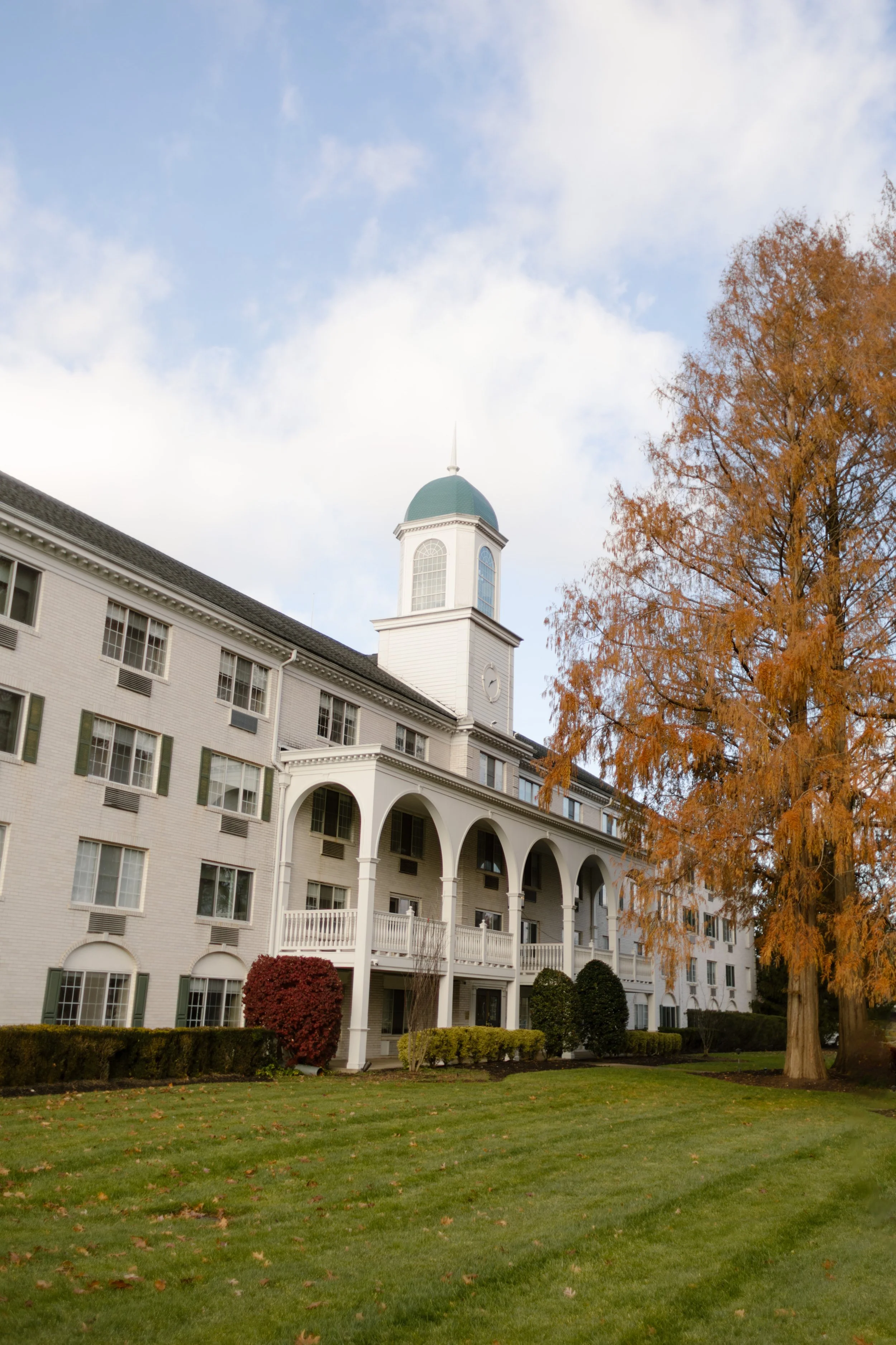 Historic white hotel venue surrounded by autumn foliage, a beautiful setting for a wedding in New York