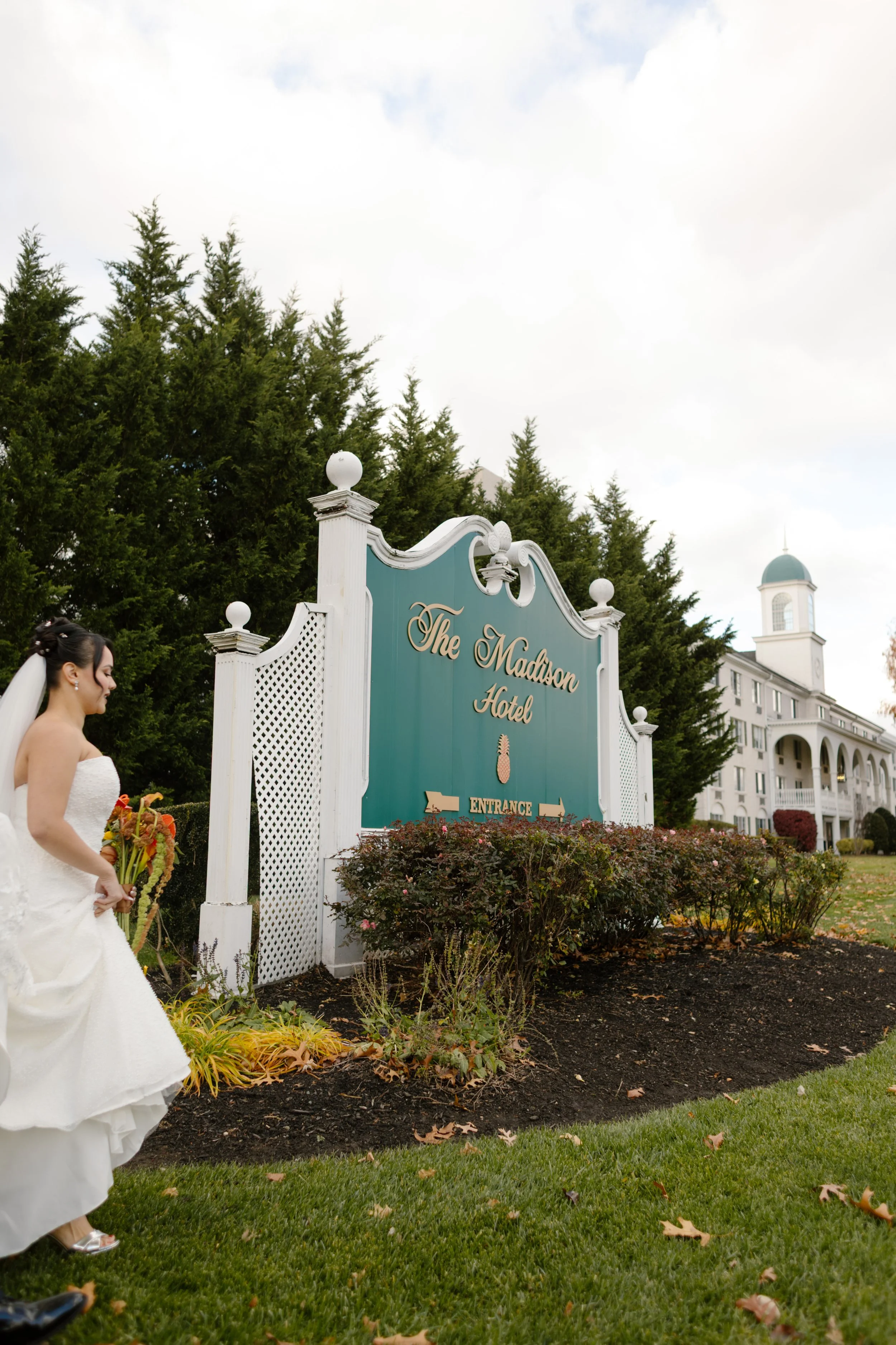 Bride walking past The Madison Hotel sign before her wedding in New York celebration
