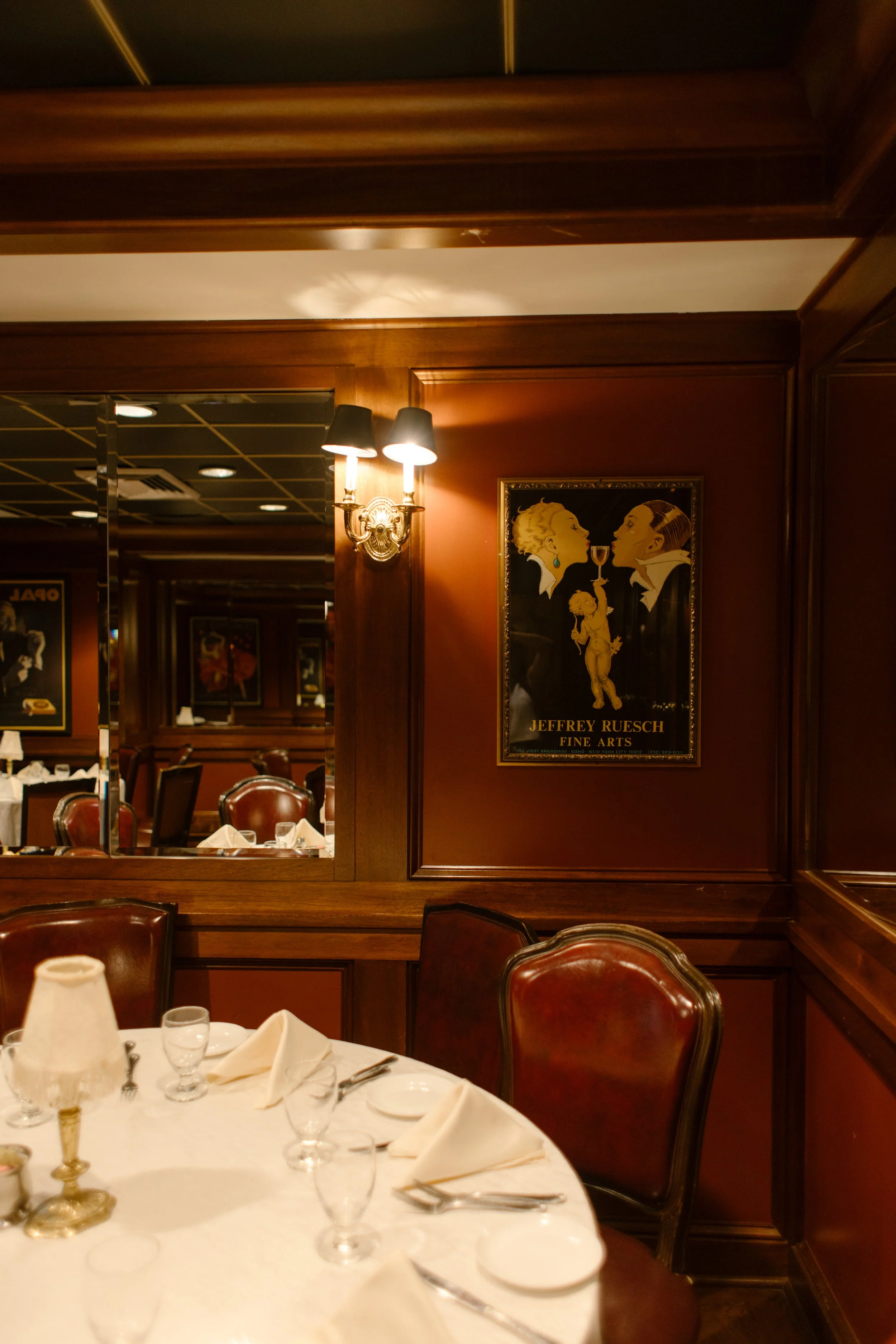 Intimate reception dining room with rich wood paneling, vintage artwork, and elegant table settings