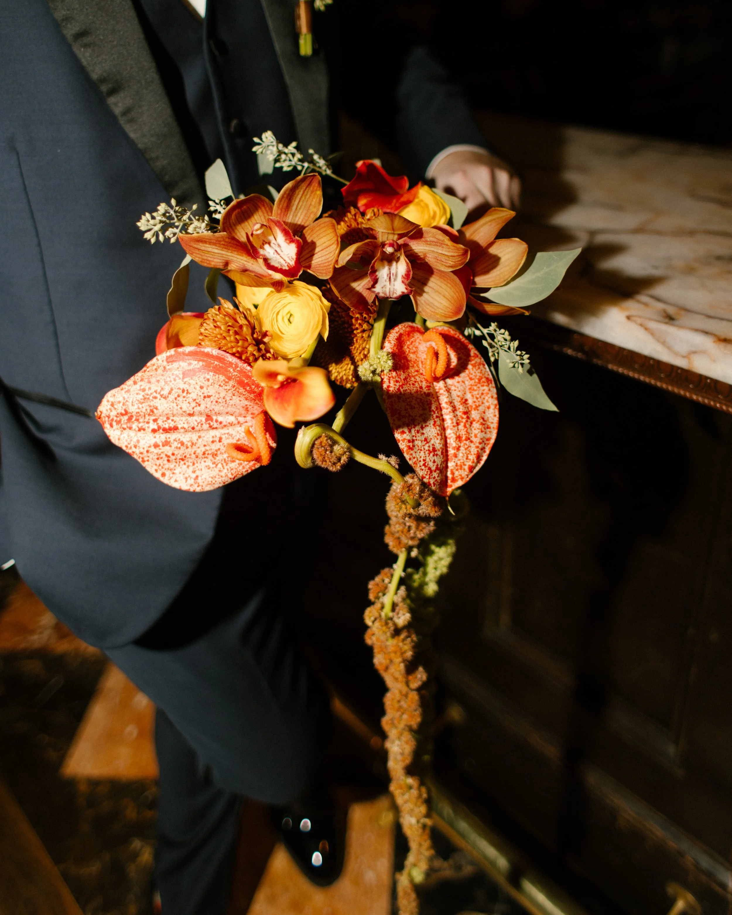 Close-up of a vibrant bridal bouquet featuring orchids, anthuriums, and seasonal autumn blooms from a wedding in New York