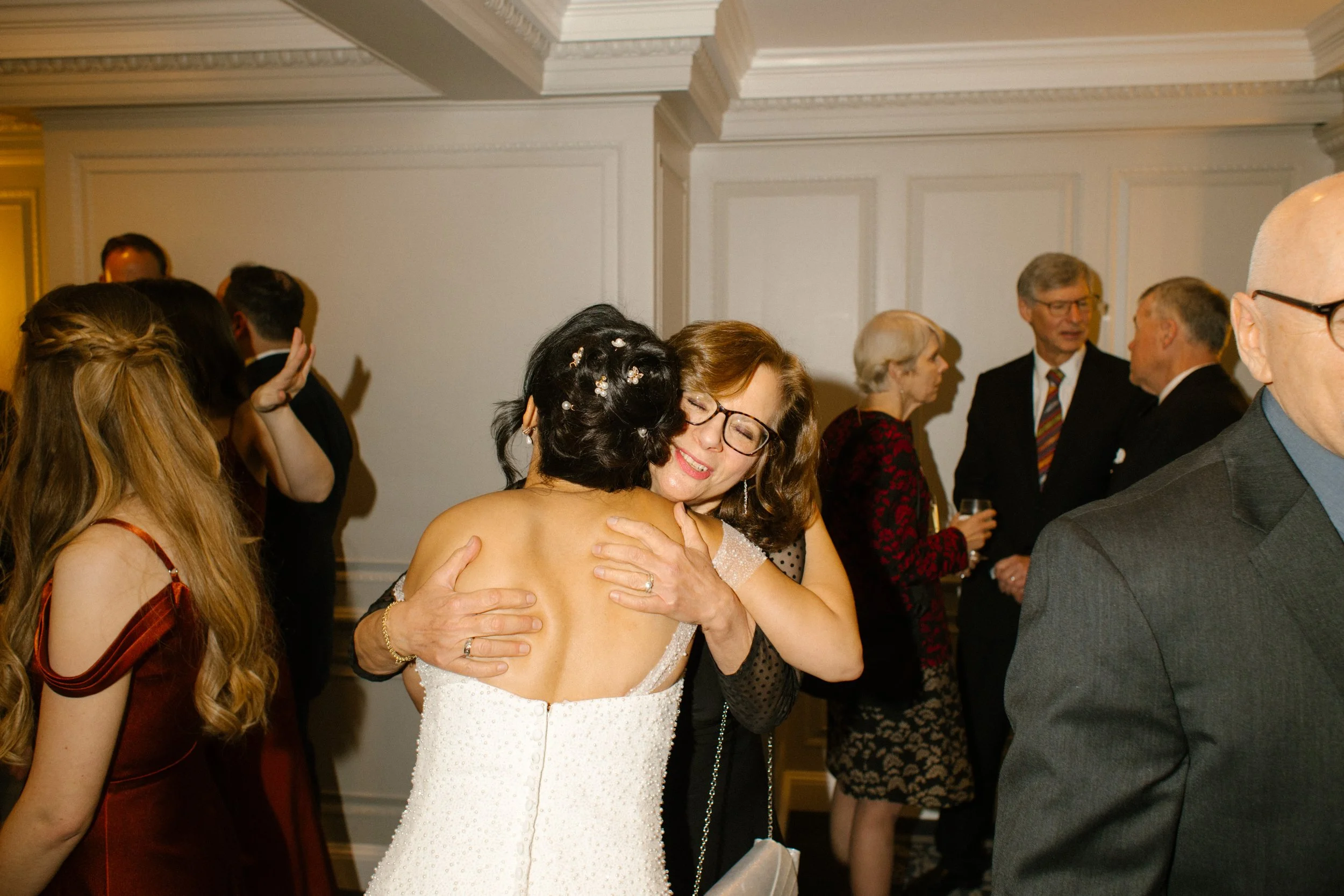 Bride sharing an emotional hug with a family member during a heartfelt wedding in New York reception
