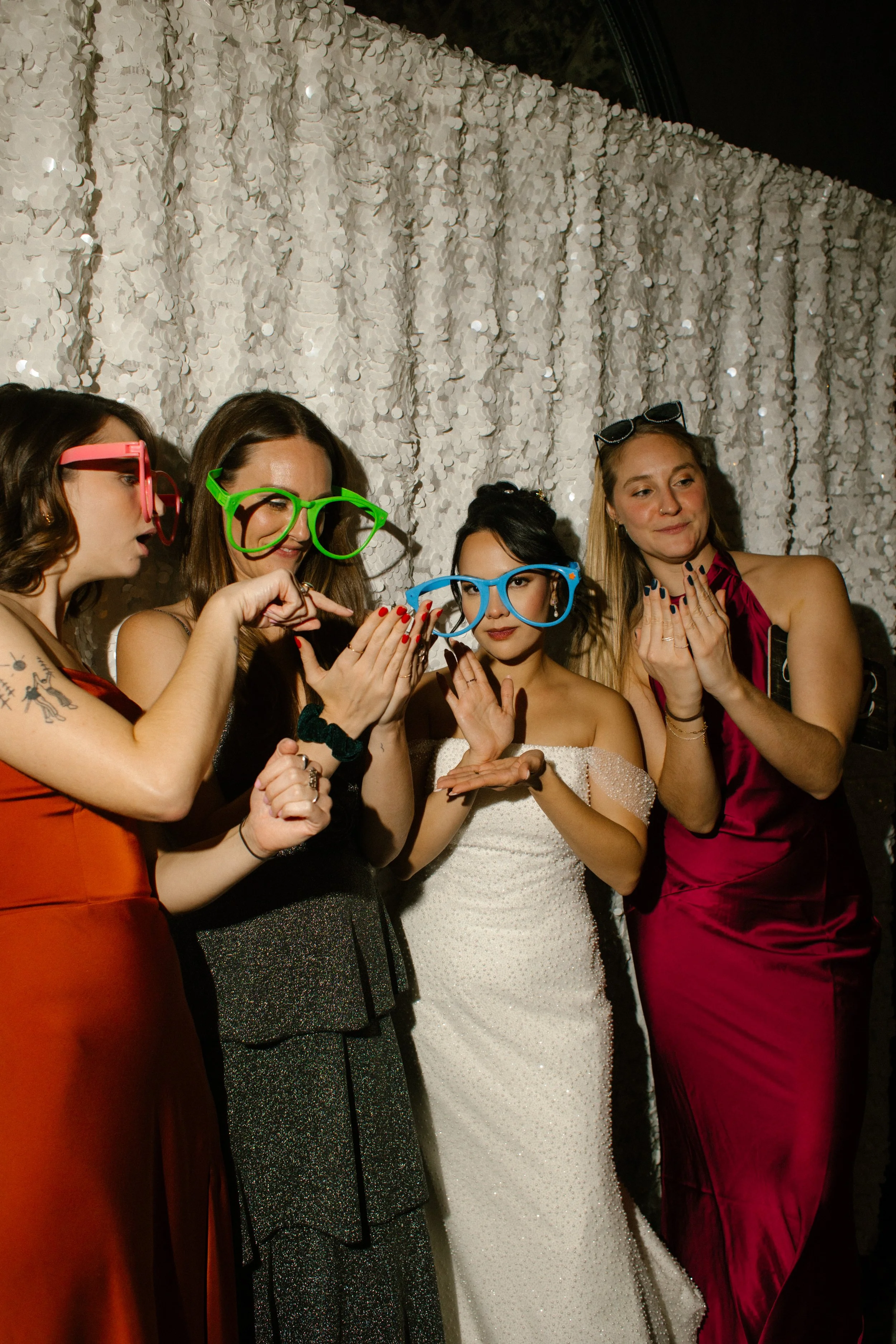 Bride and guests wearing oversized party glasses at a fun wedding in New York photo booth moment