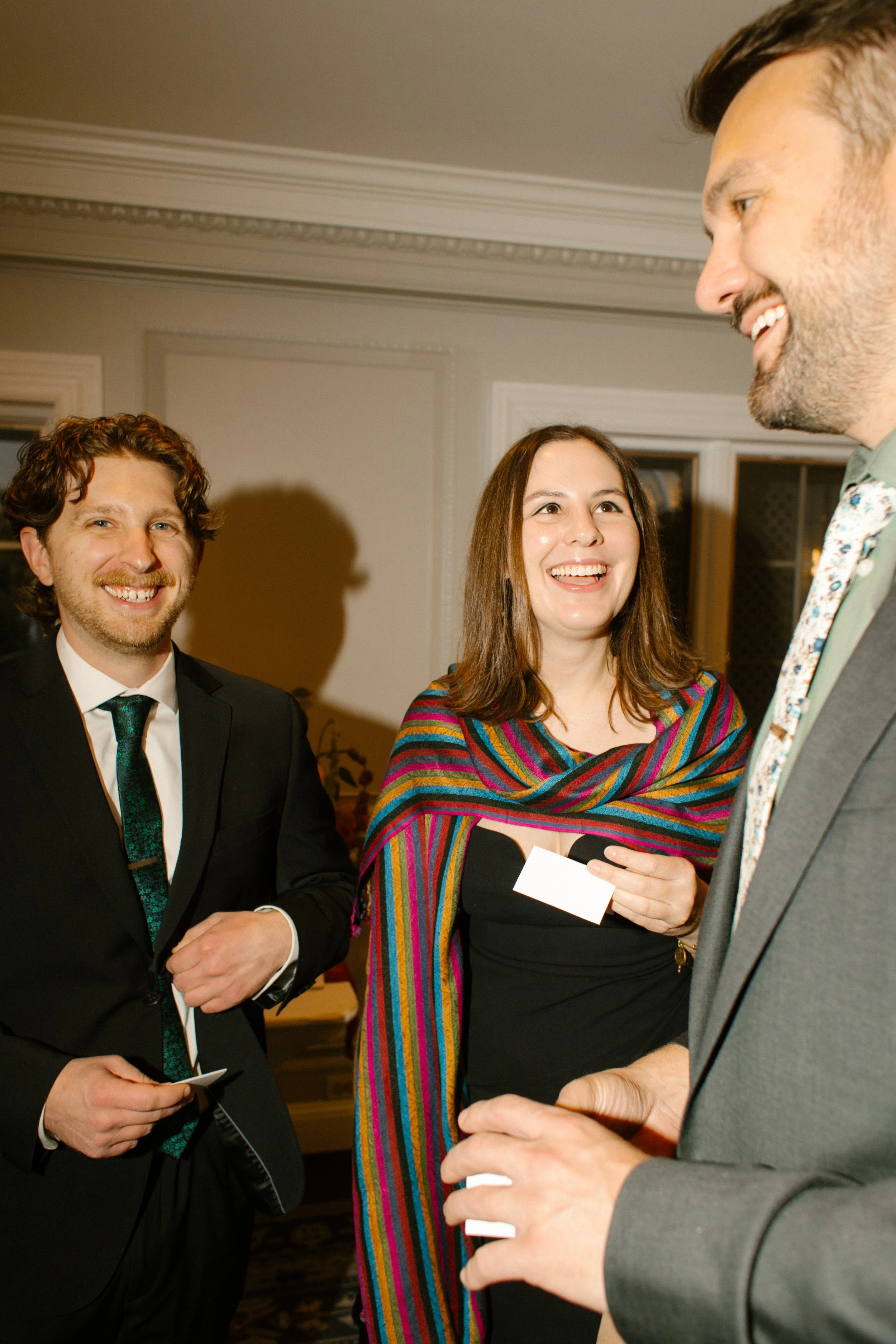 Wedding guests chatting and laughing together during cocktail hour at an elegant reception