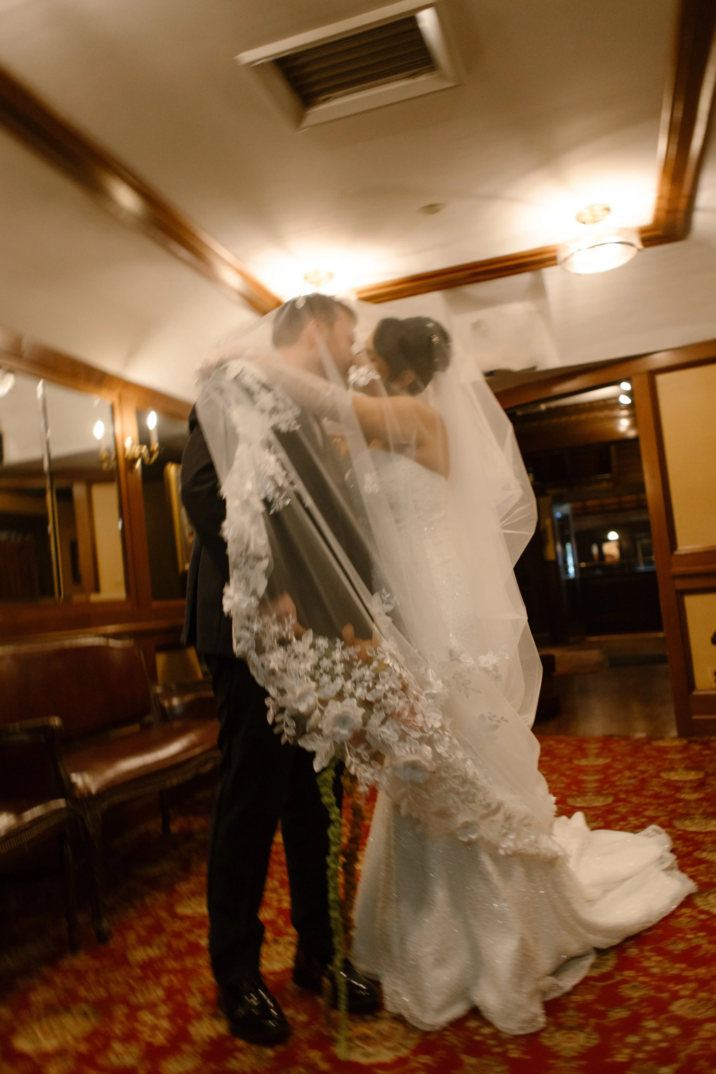 Newlyweds embracing outside The Madison Hotel with autumn wedding bouquet and greenery