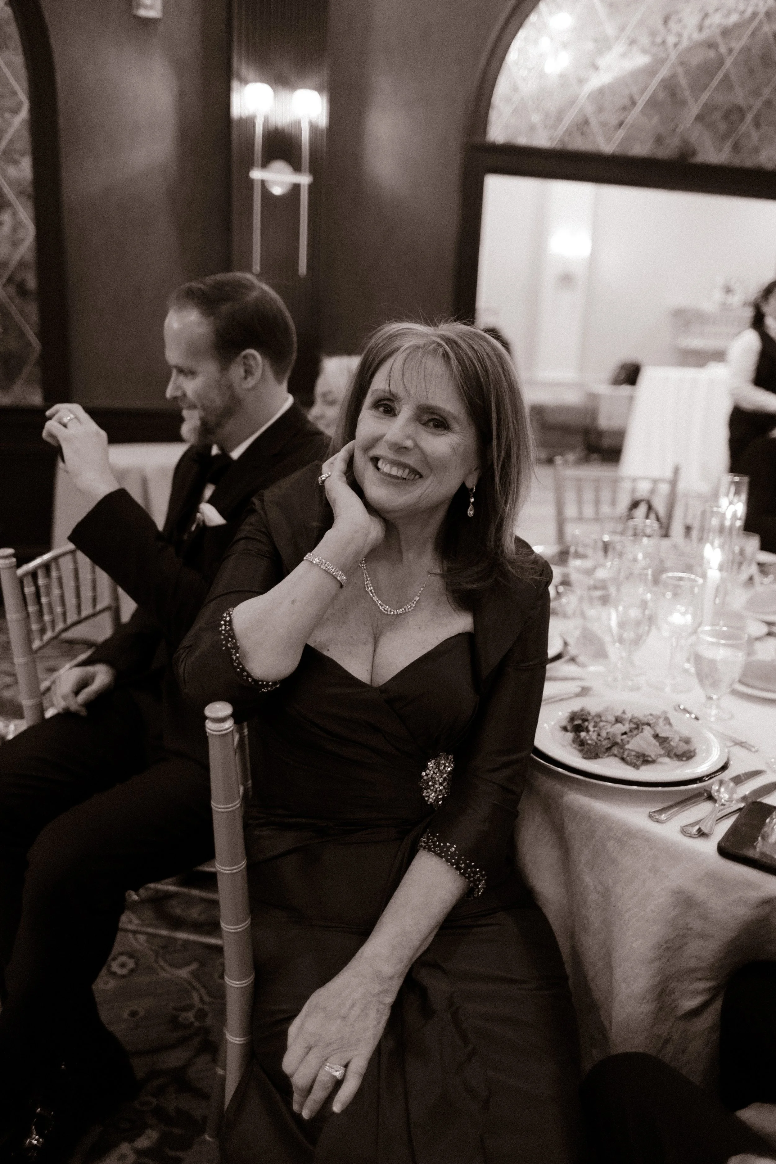 Mother of the groom smiling at her reception table during a wedding in New York