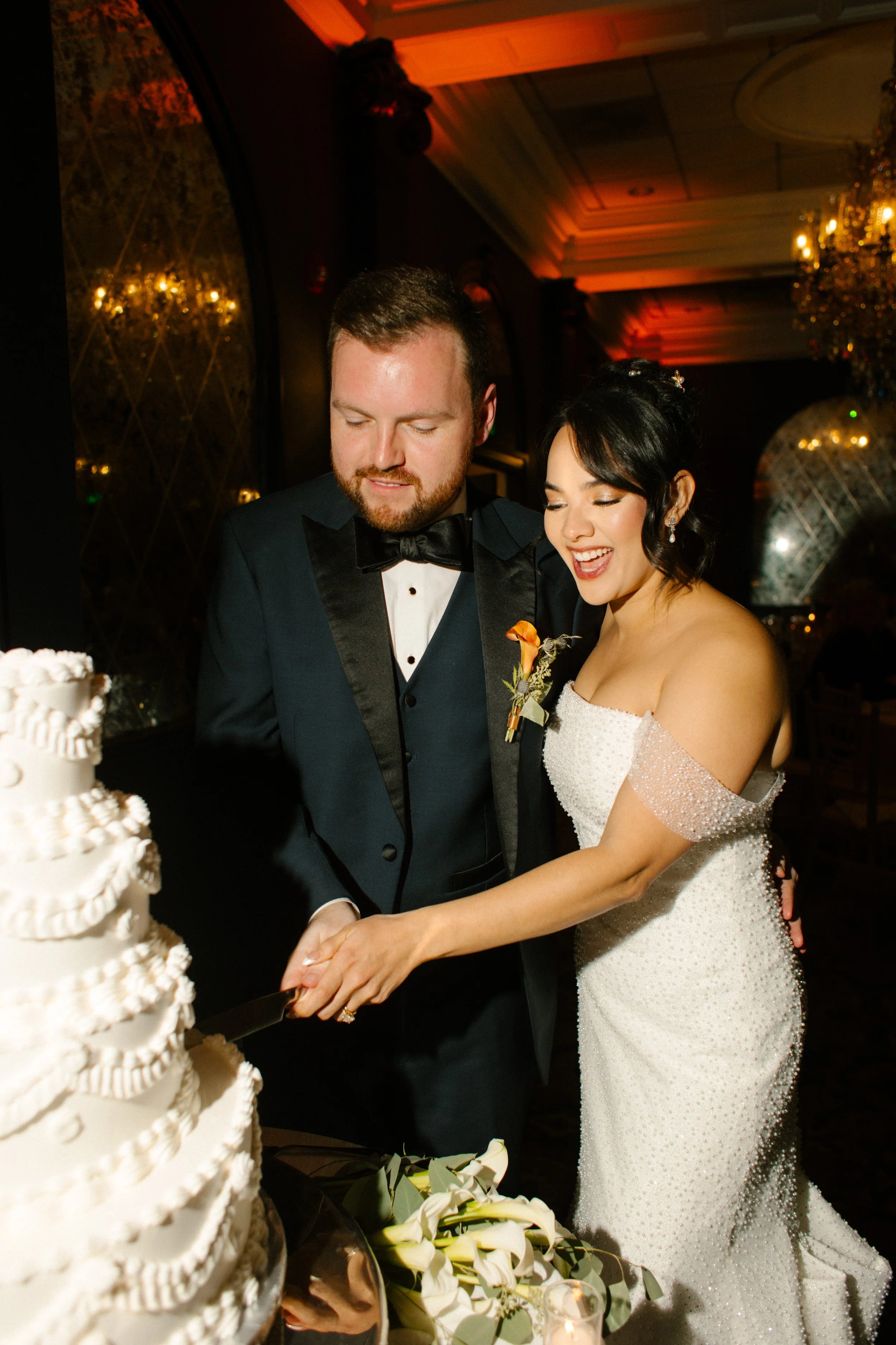 Bride and groom cutting their wedding cake together during a joyful wedding in New York reception