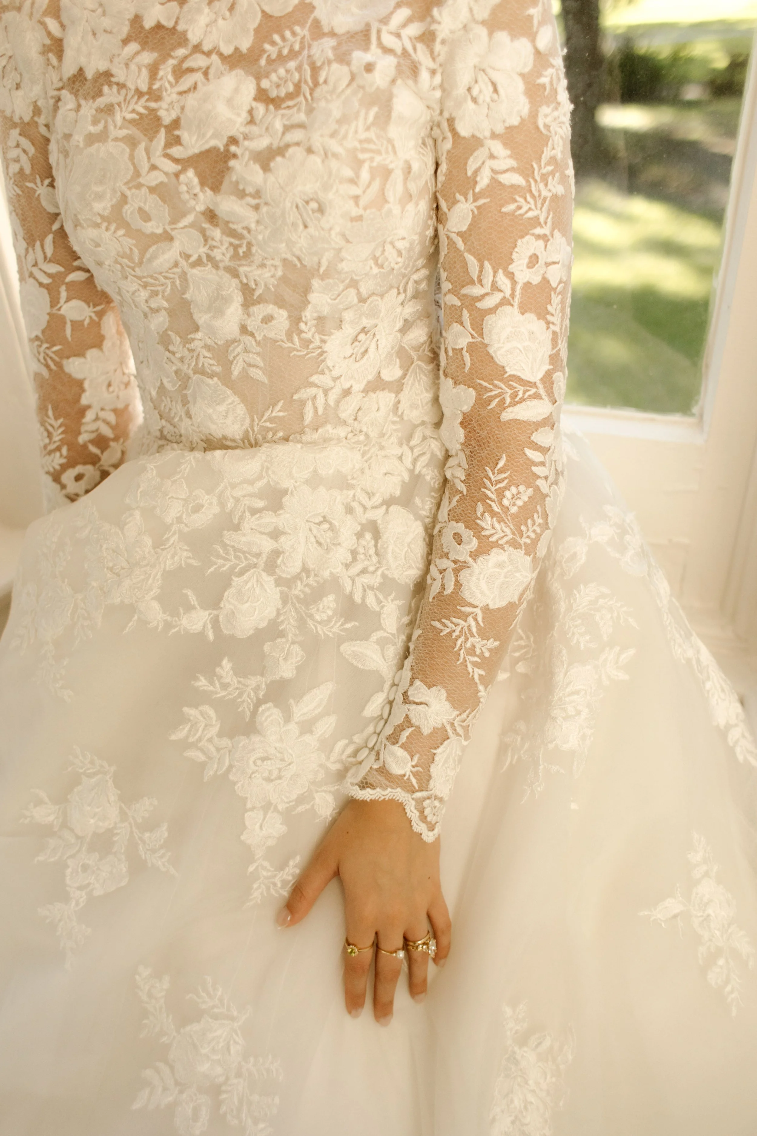 Detailed lace wedding gown featuring long sleeves and intricate floral embroidery