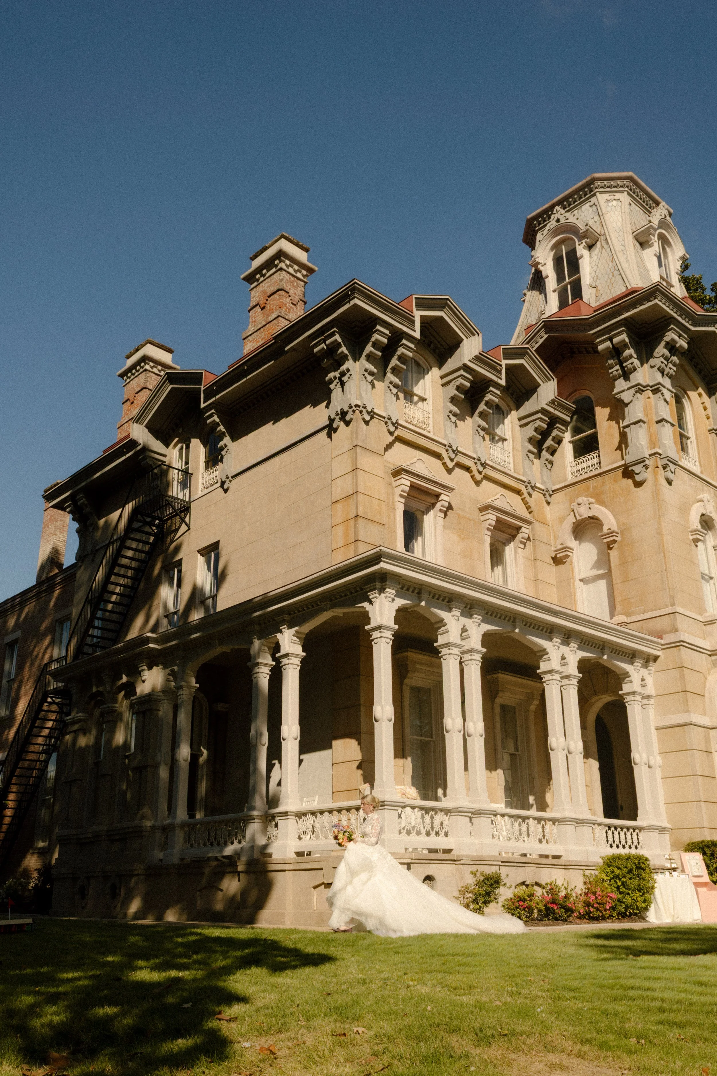 Bride posing in front of a historic estate, showcasing dramatic 2027 wedding trends