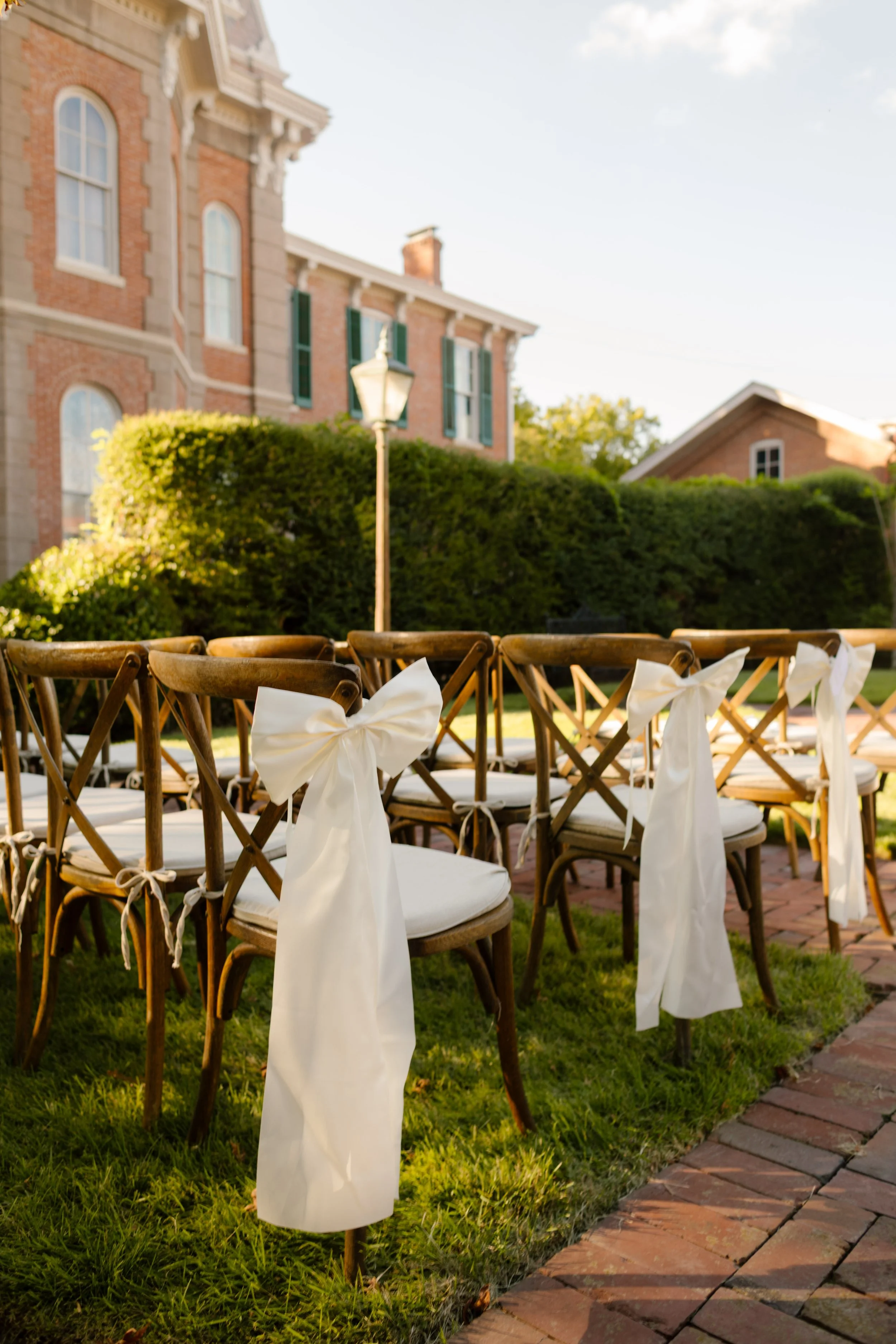 Ceremony chairs decorated with flowing white bows, a timeless detail in 2027 wedding trends