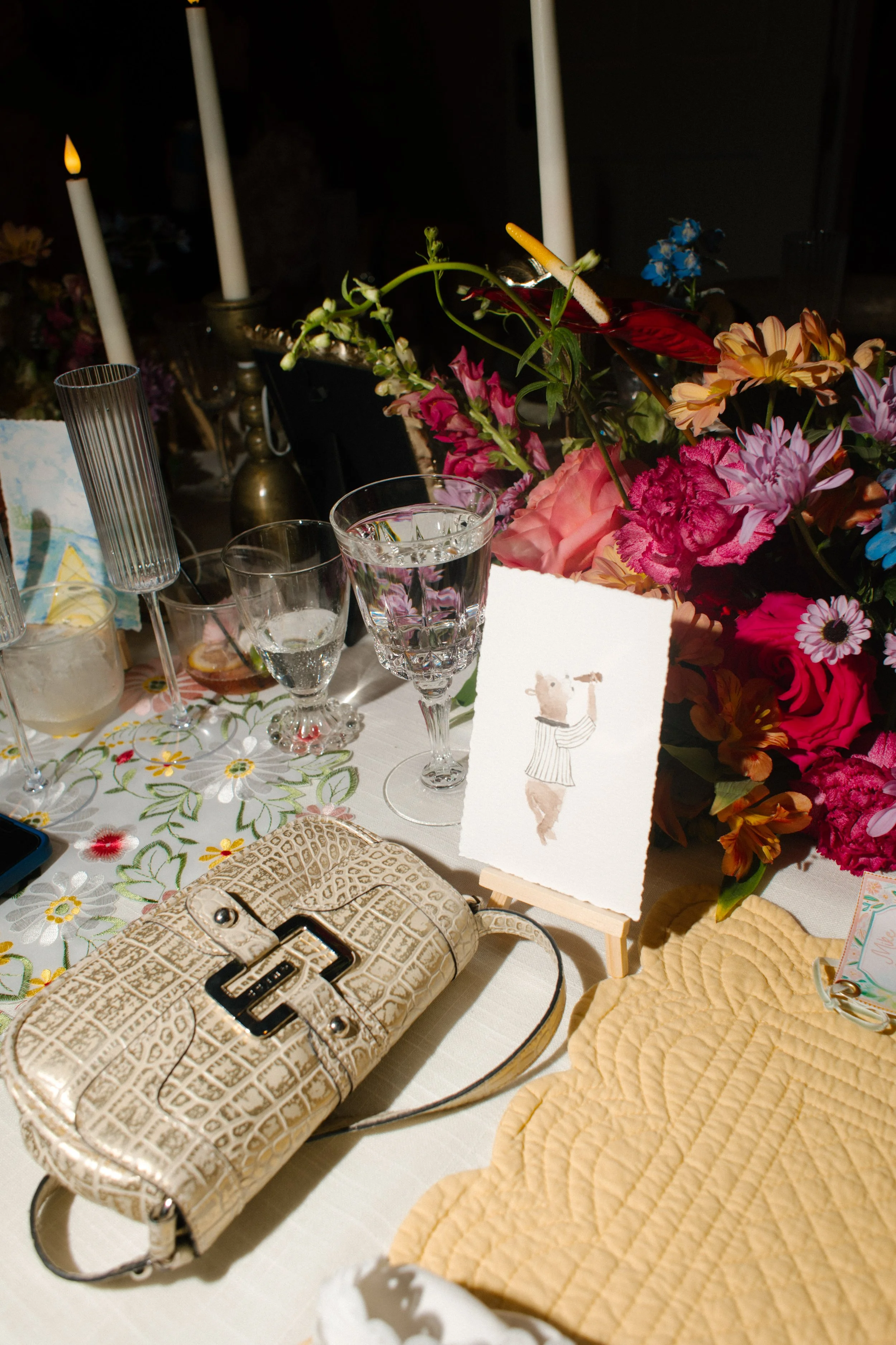 Illustrated animal table number surrounded by colorful florals, reflecting playful 2027 wedding trends