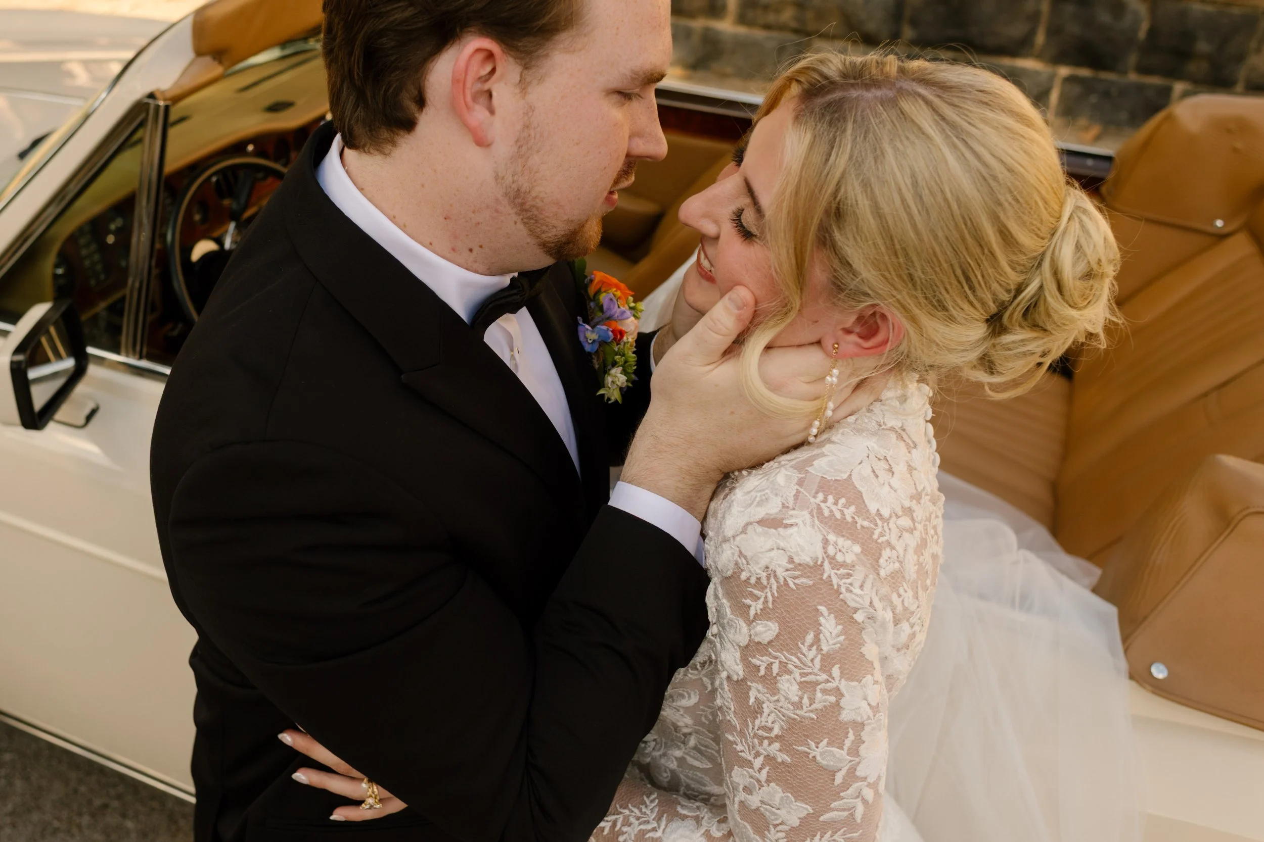 Romantic portrait of newlyweds beside a vintage convertible, highlighting fashion-forward 2027 wedding trends