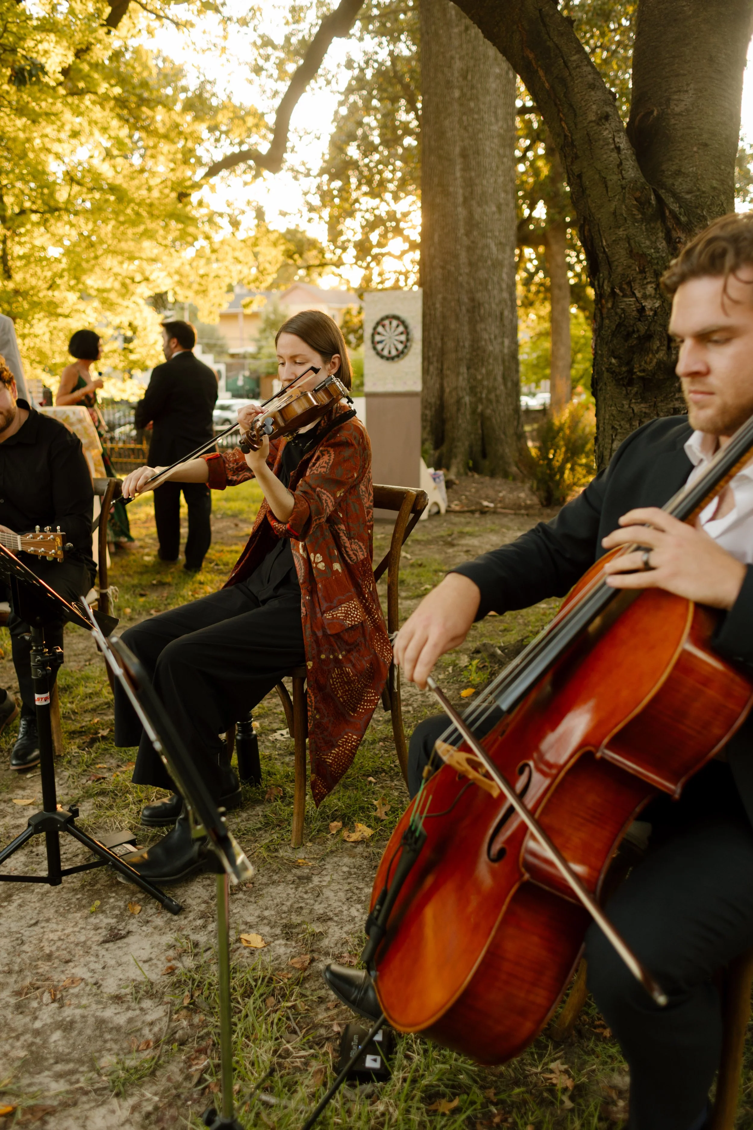 Live string musicians performing during an outdoor wedding ceremony