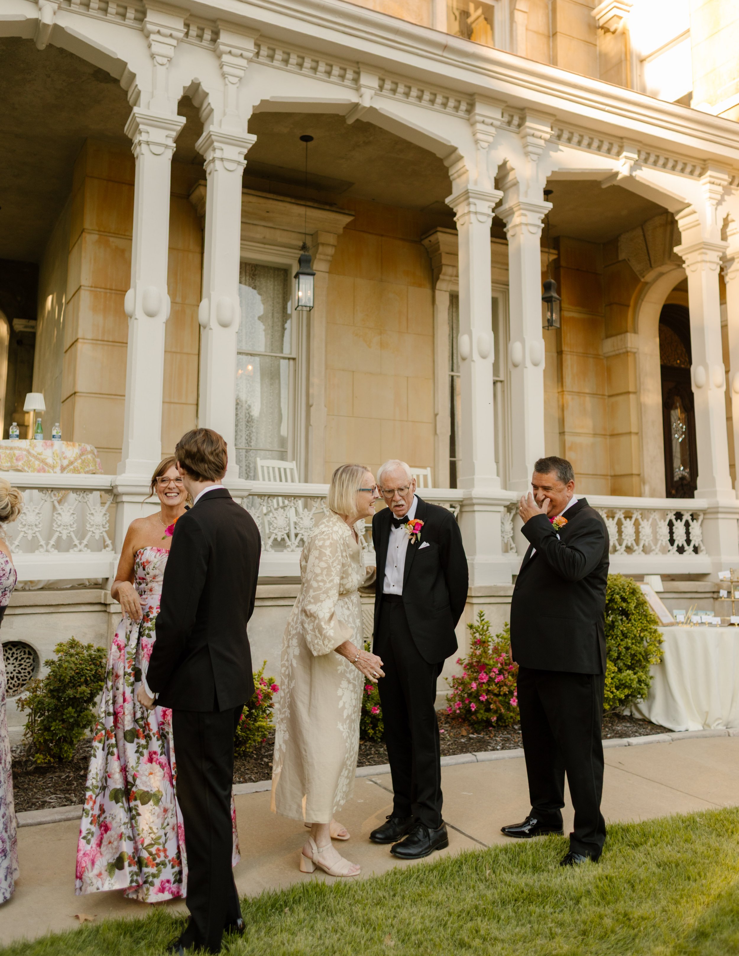 Family members and guests gathering outside a historic estate before the ceremony