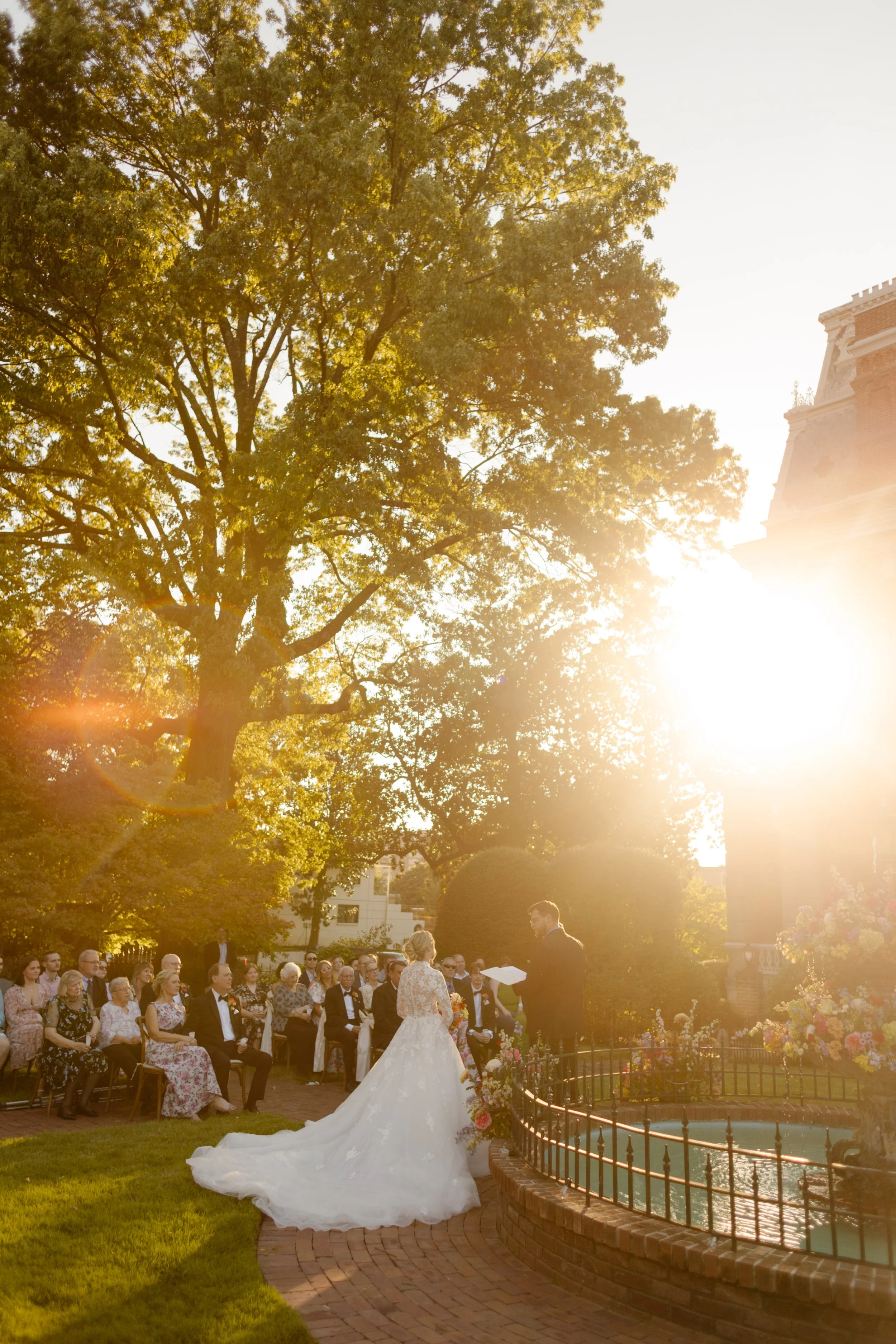 Outdoor wedding ceremony beside a floral fountain at golden hour, reflecting elegant 2027 wedding trends