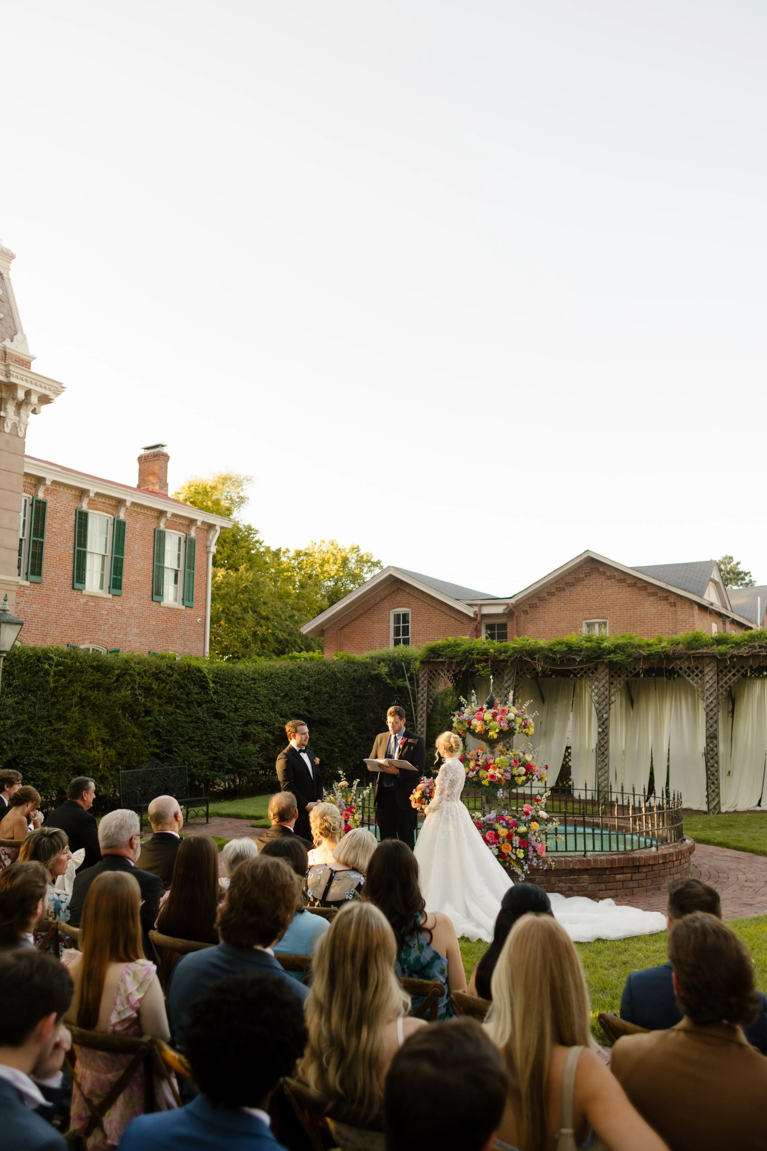 Guests gathered around a floral fountain ceremony backdrop, a standout feature in 2027 wedding trends