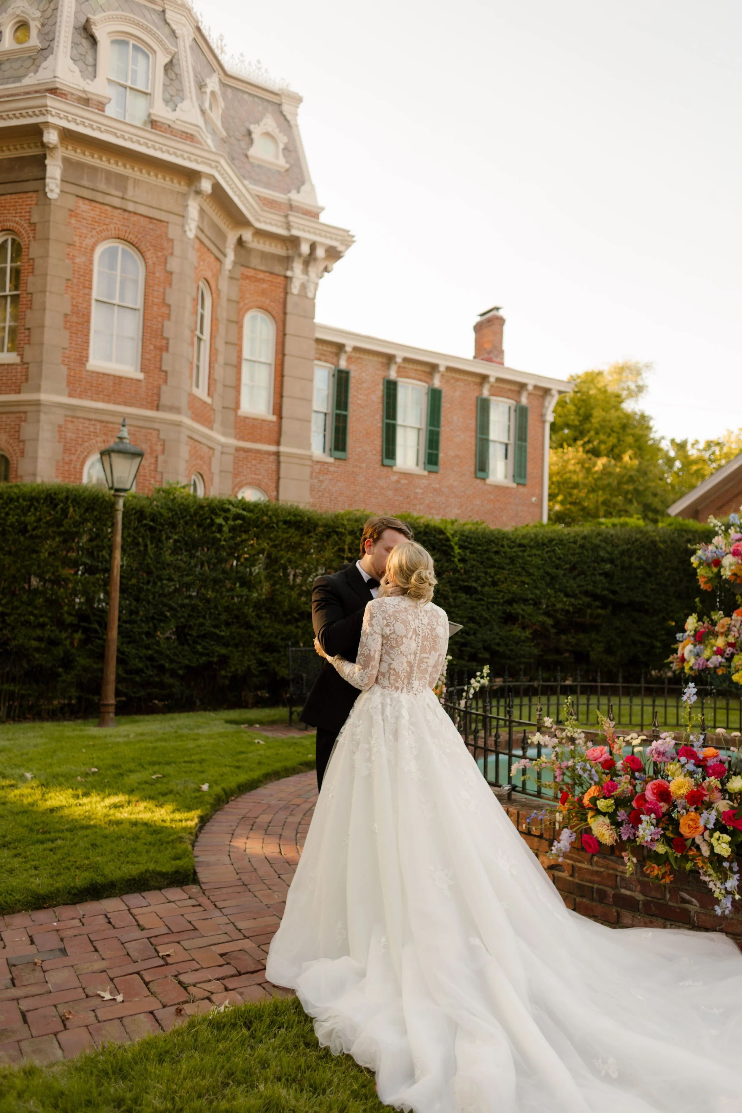 Newlyweds sharing a quiet moment beside colorful floral installations after their ceremony