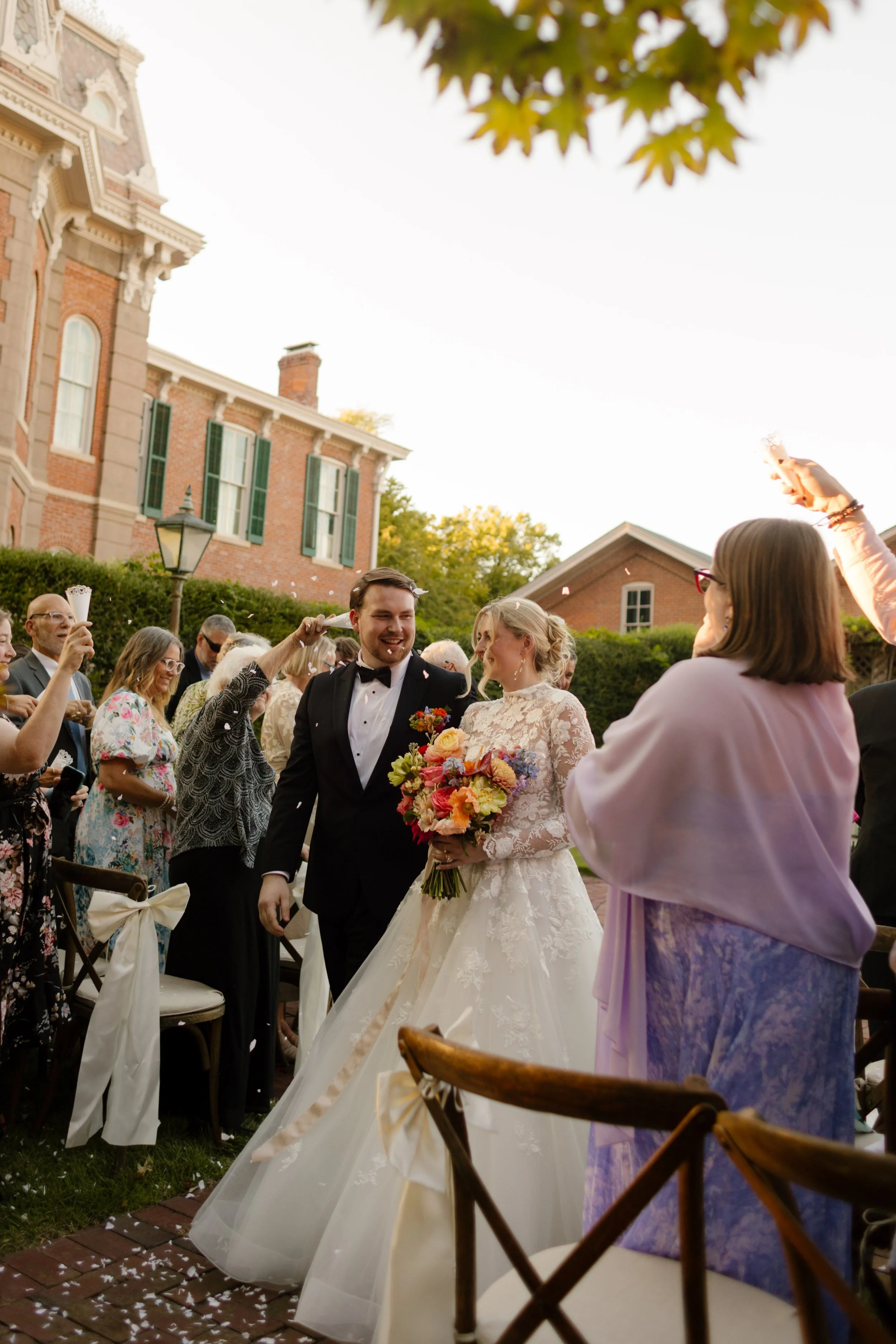 Bride and groom walking through a celebratory guest send-off, showcasing joyful 2027 wedding trends