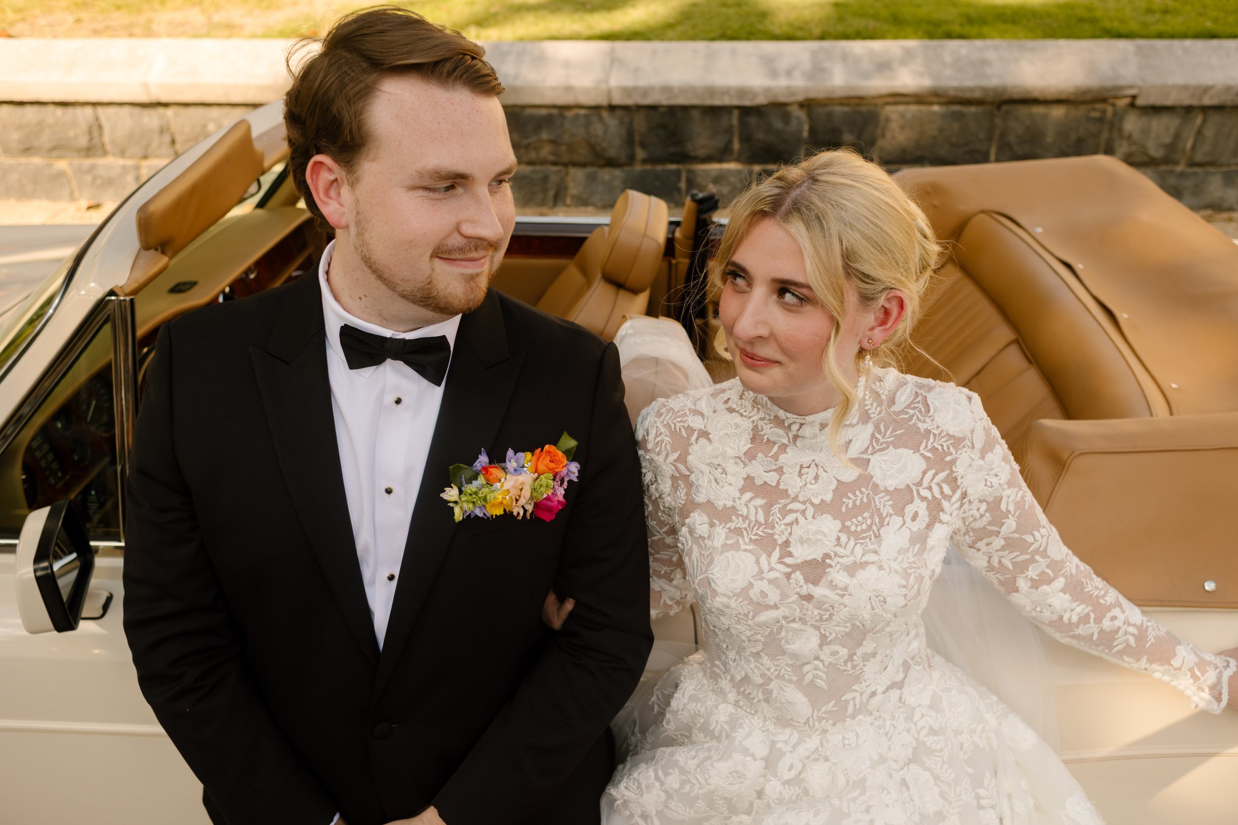 Couple sitting together in a vintage convertible, featuring fashion-forward bridal styling inspired by 2027 wedding trends