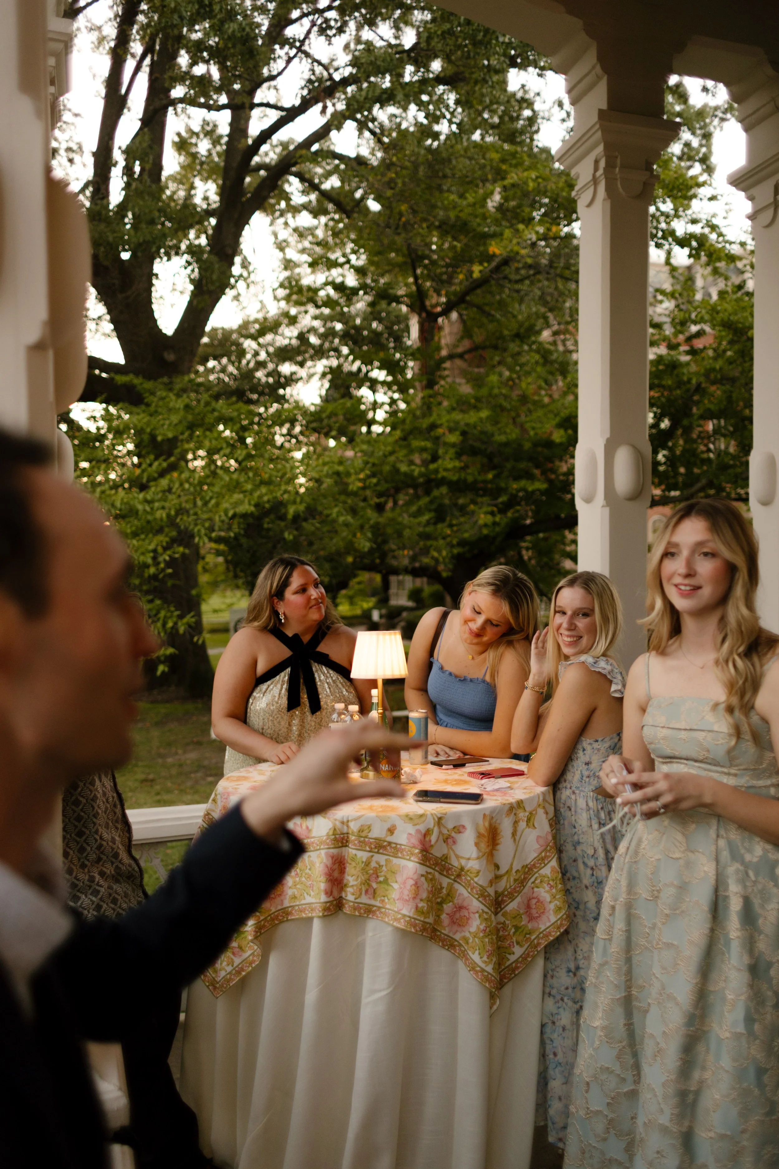 Wedding guests gathered on the veranda enjoying conversation and cocktails as the evening celebration begins