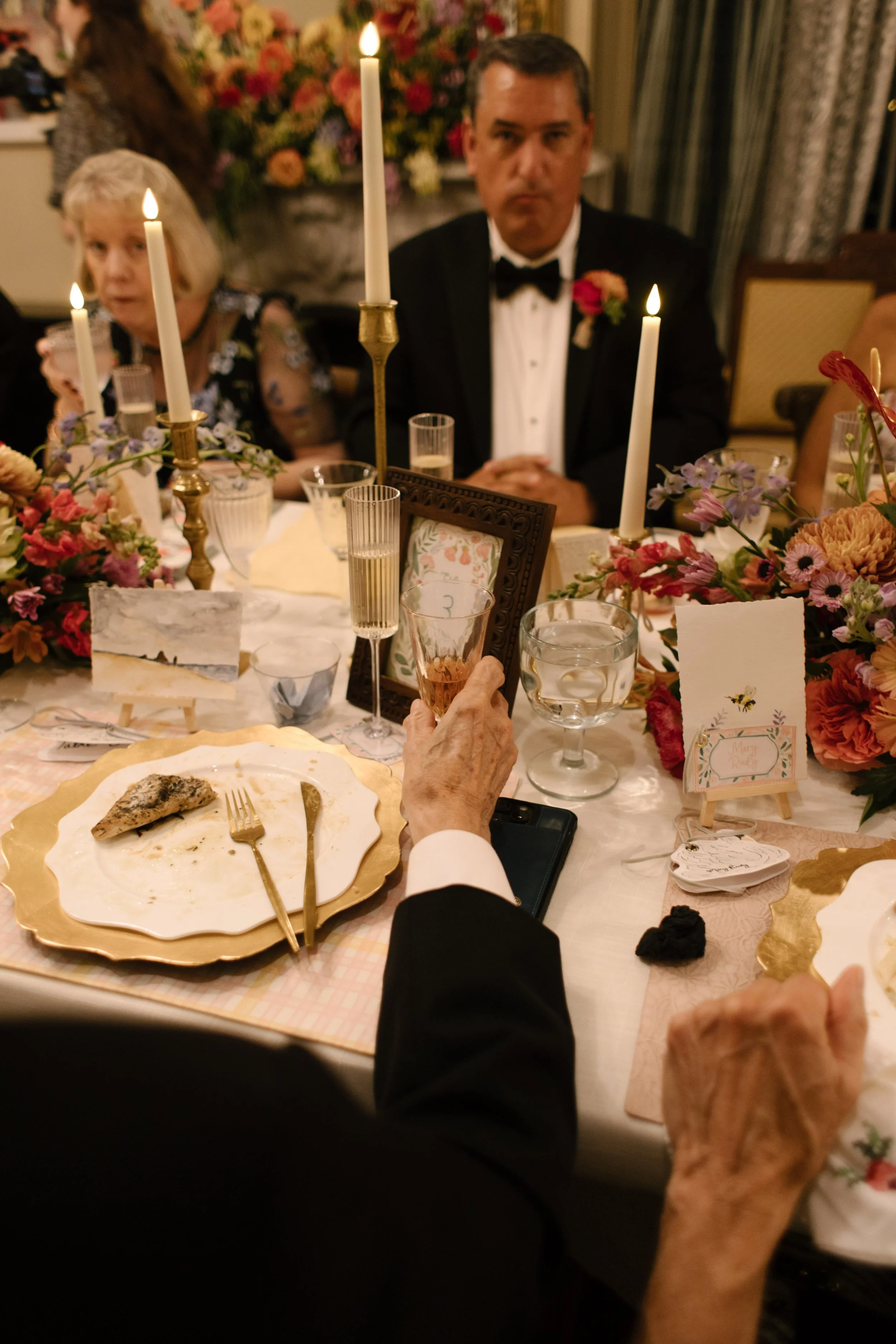 Guests admiring custom watercolor wedding stationery and meaningful keepsakes displayed at their reception table