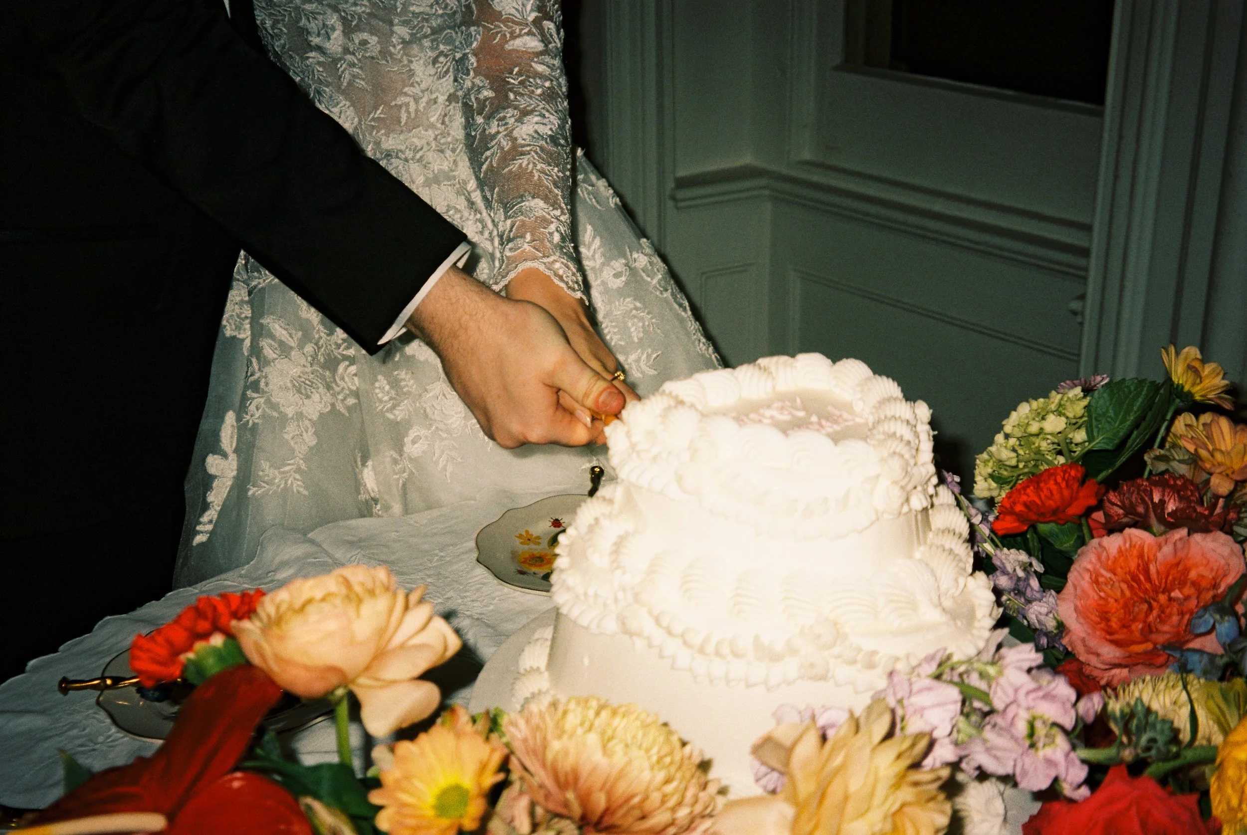 The newlyweds cutting their wedding cake during a joyful reception celebration with family and friends