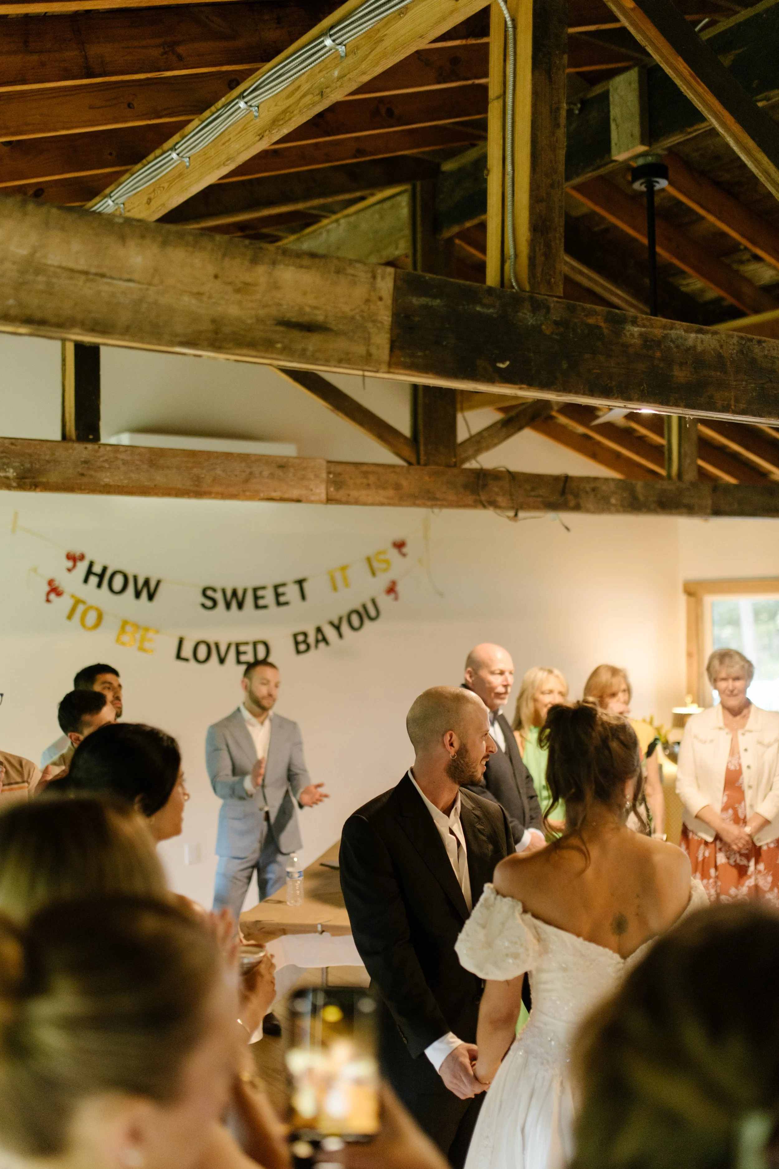 Guests gather inside a rustic barn during a wedding rehearsal dinner before the celebration begins