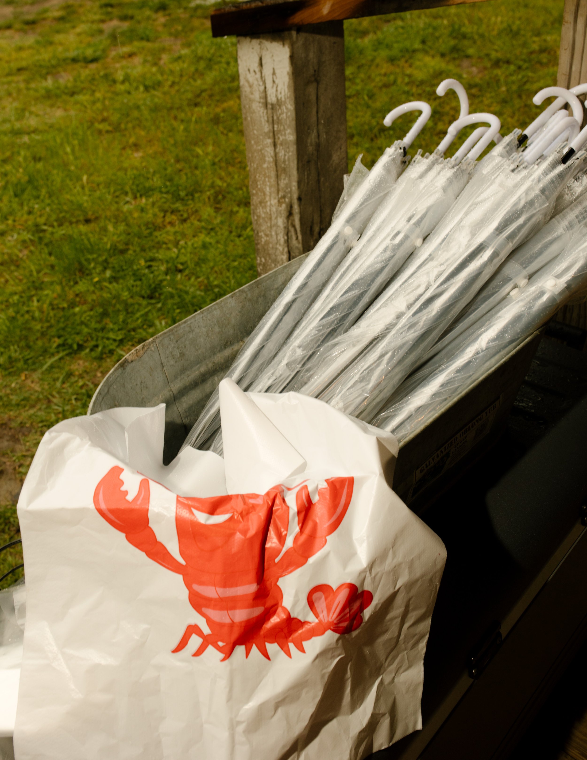 Clear umbrellas and crawfish-themed details prepared for a rainy wedding weekend celebration