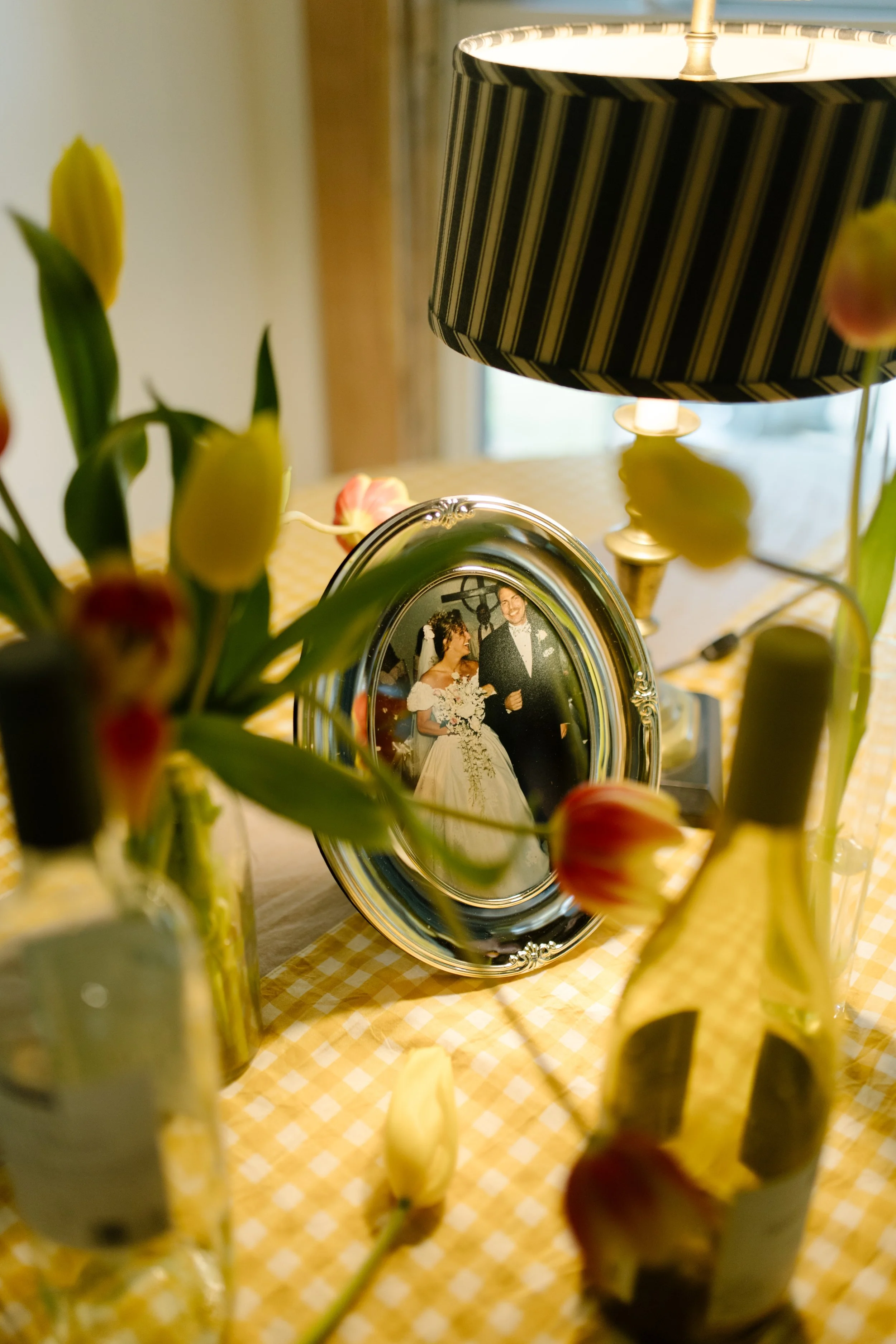 Framed family wedding photo displayed among flowers and table decor during a wedding weekend gathering