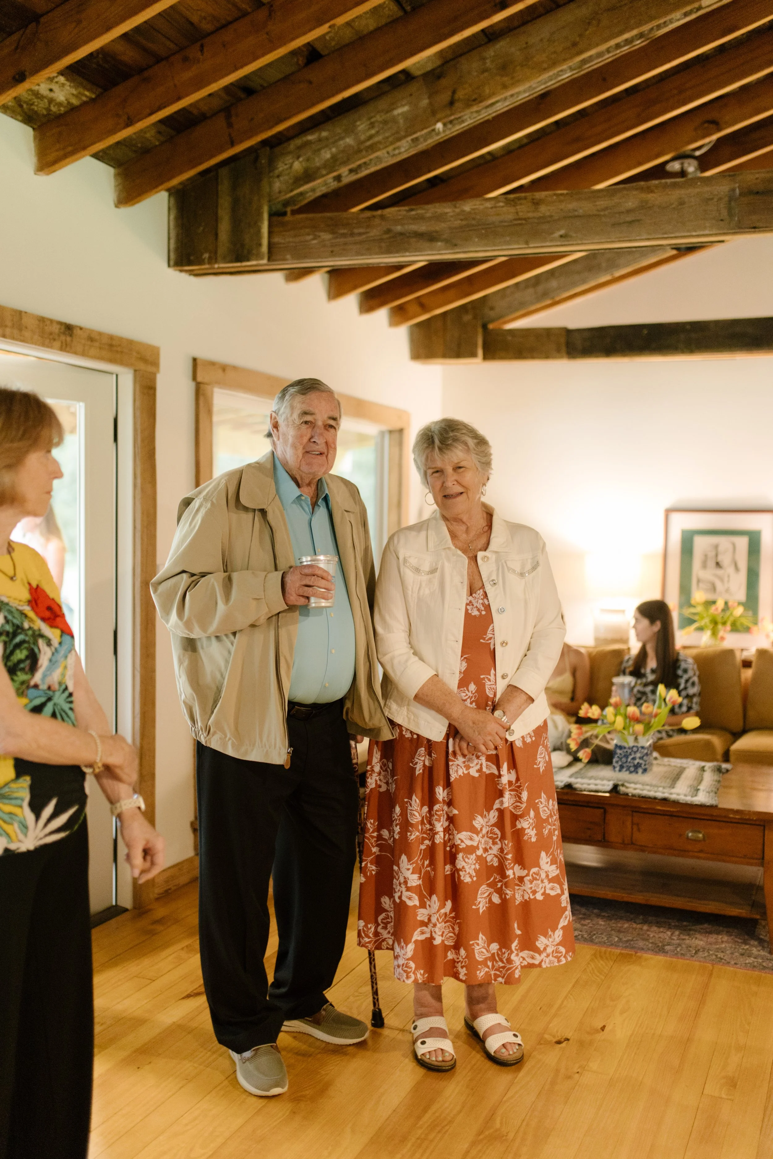Grandparents visiting with family before the wedding rehearsal dinner begins at a rustic Mississippi venue