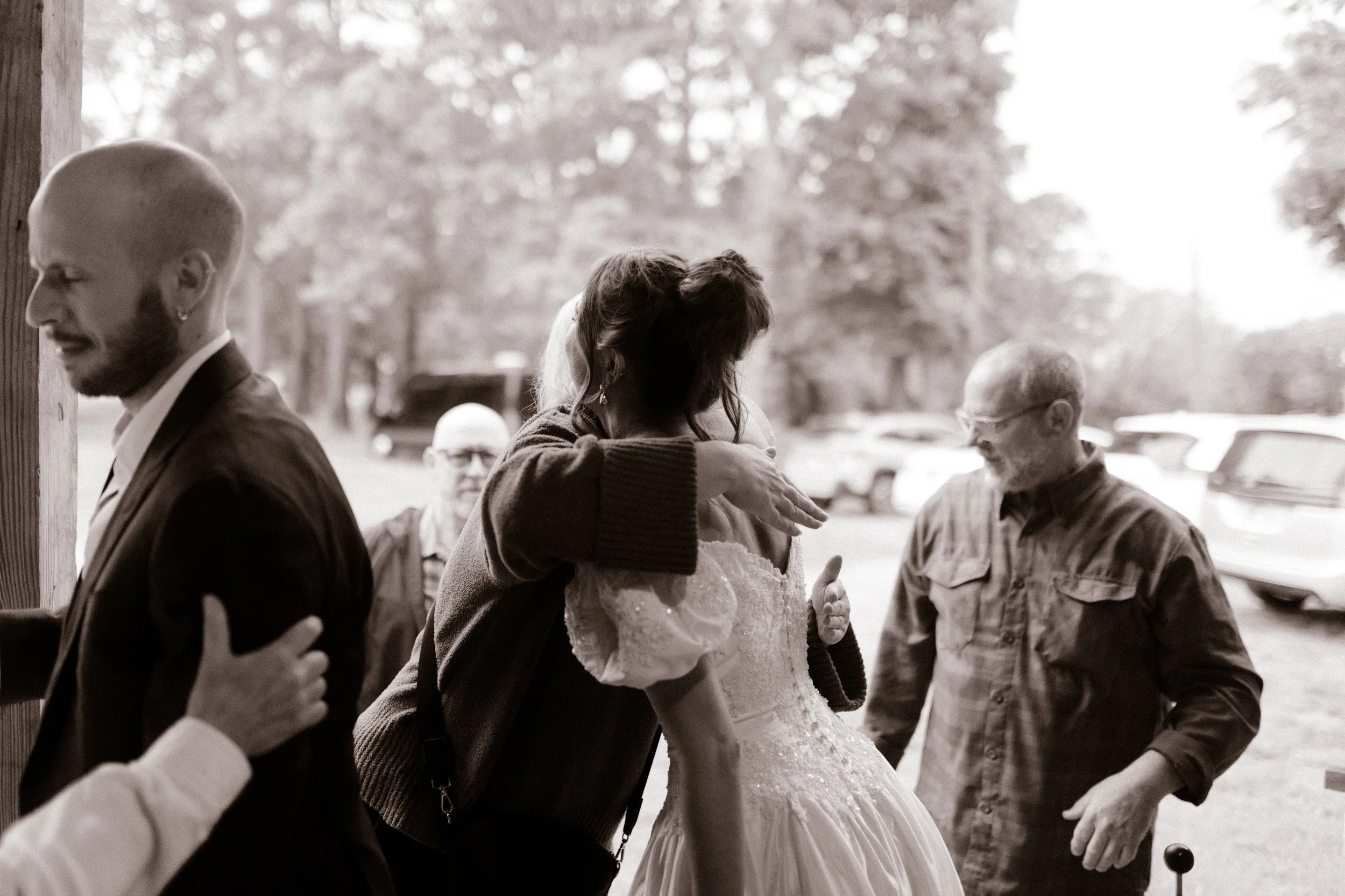 Bride hugging a guest as loved ones arrive for the wedding rehearsal dinner