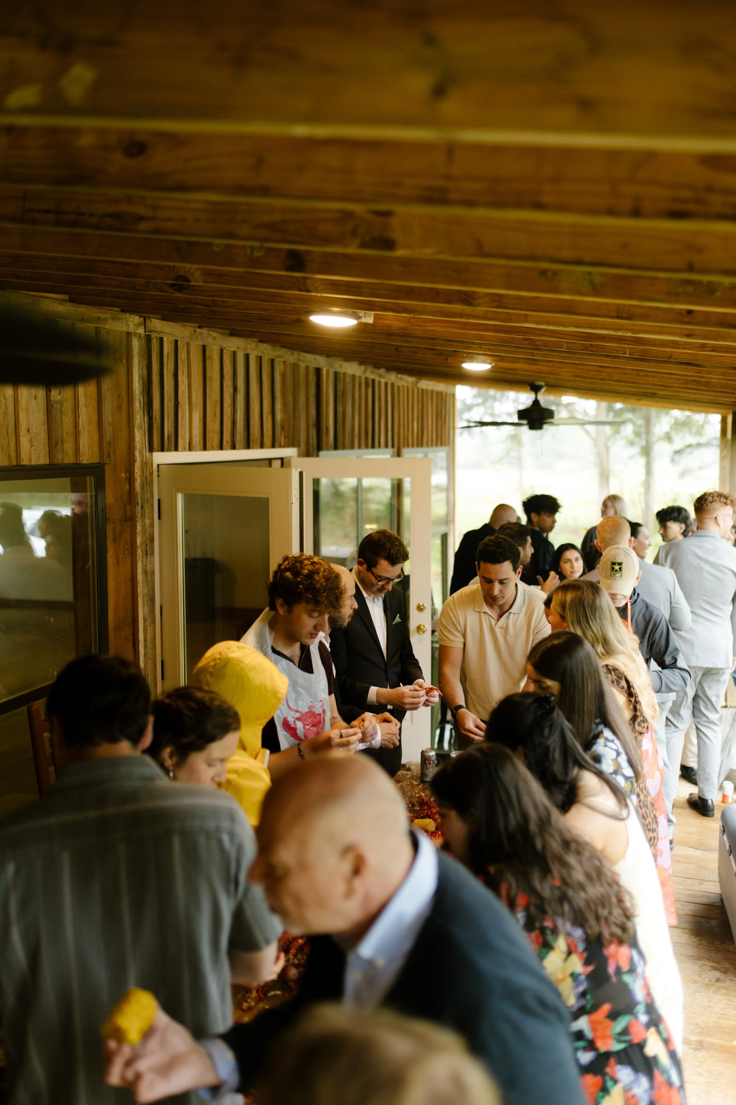 Friends and family gathered around a crawfish boil during a wedding rehearsal dinner celebration