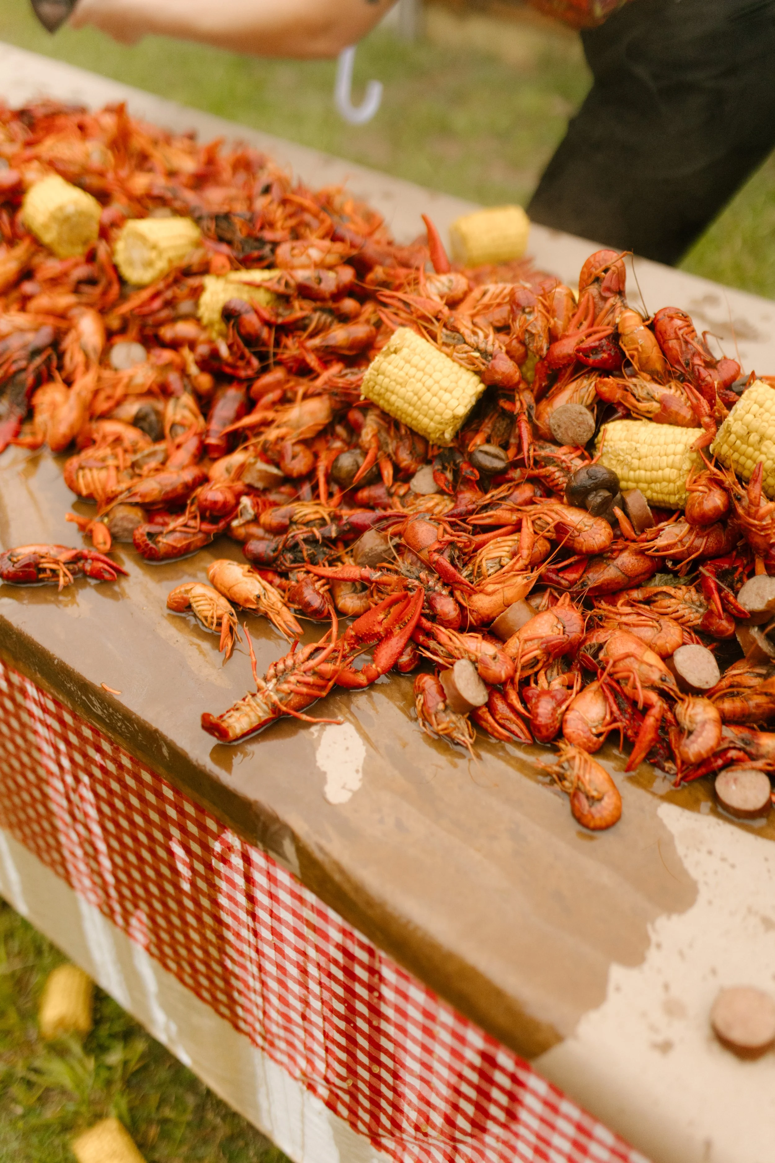Crawfish boil spread with corn and sausage prepared for a Southern wedding rehearsal dinner