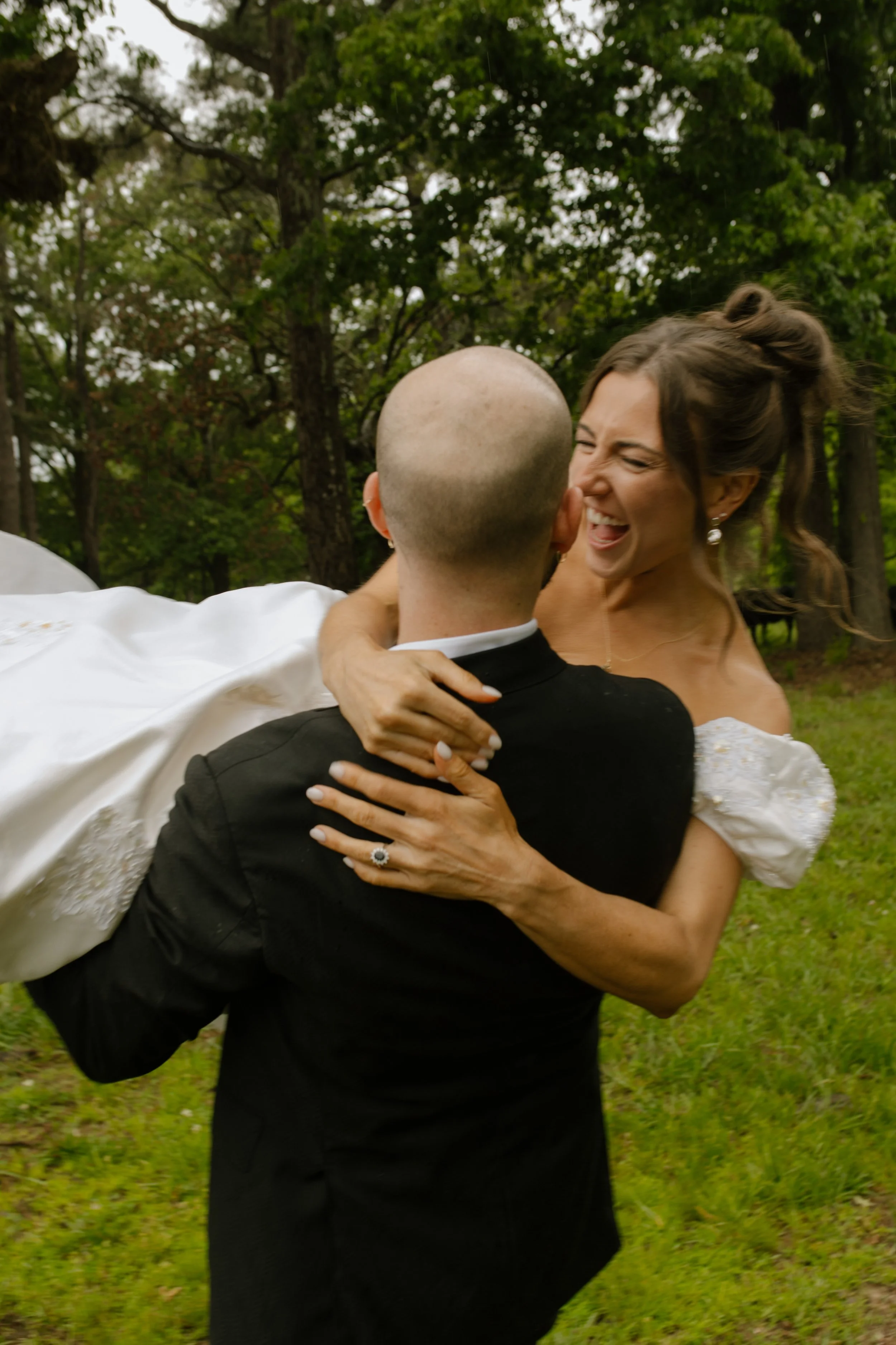 Groom carrying a laughing bride through a field during rehearsal dinner photography portraits